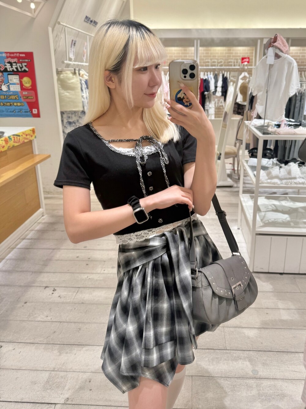 グレー系のショルダーバッグ、ブラック系のスカート、ブラック系のTシャツ/カットソーを着用したレディースの夏コーディネートの2枚目の写真