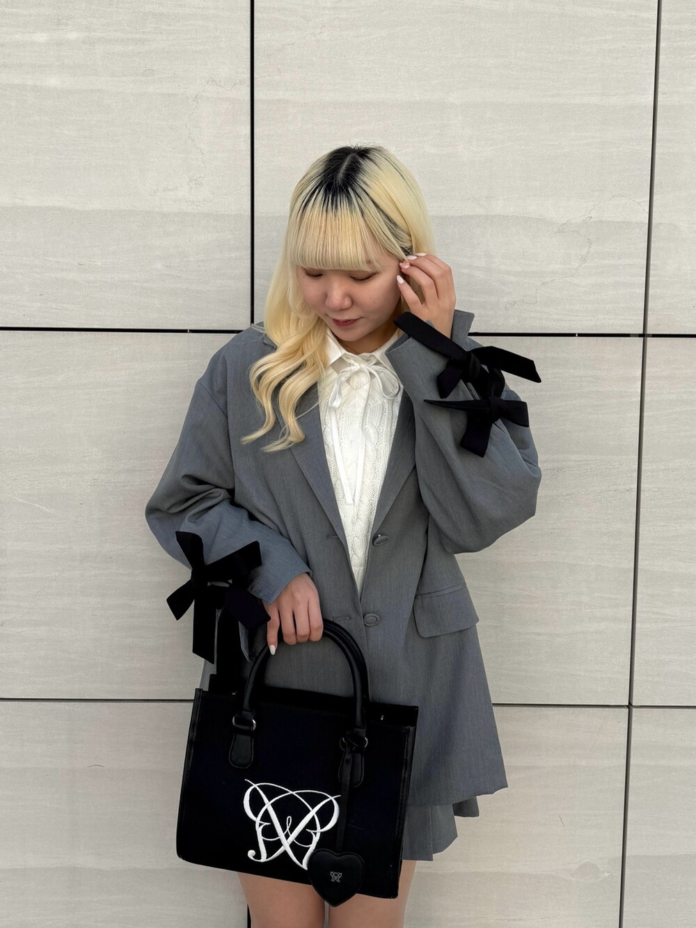 ブラック系のトートバッグ、ホワイト系のシャツ/ブラウス、グレー系のその他アウターを着用したレディースの春コーディネートの3枚目の写真