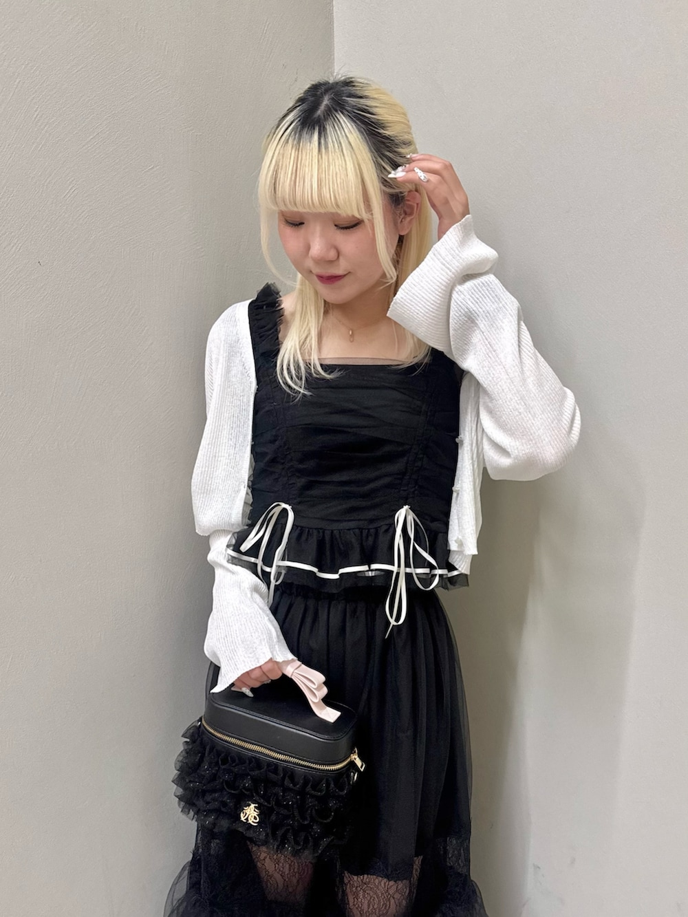 ブラック系のスカート、ブラック系のショルダーバッグ、ブラック系のサンダルを着用したレディースの春コーディネートの6枚目の写真