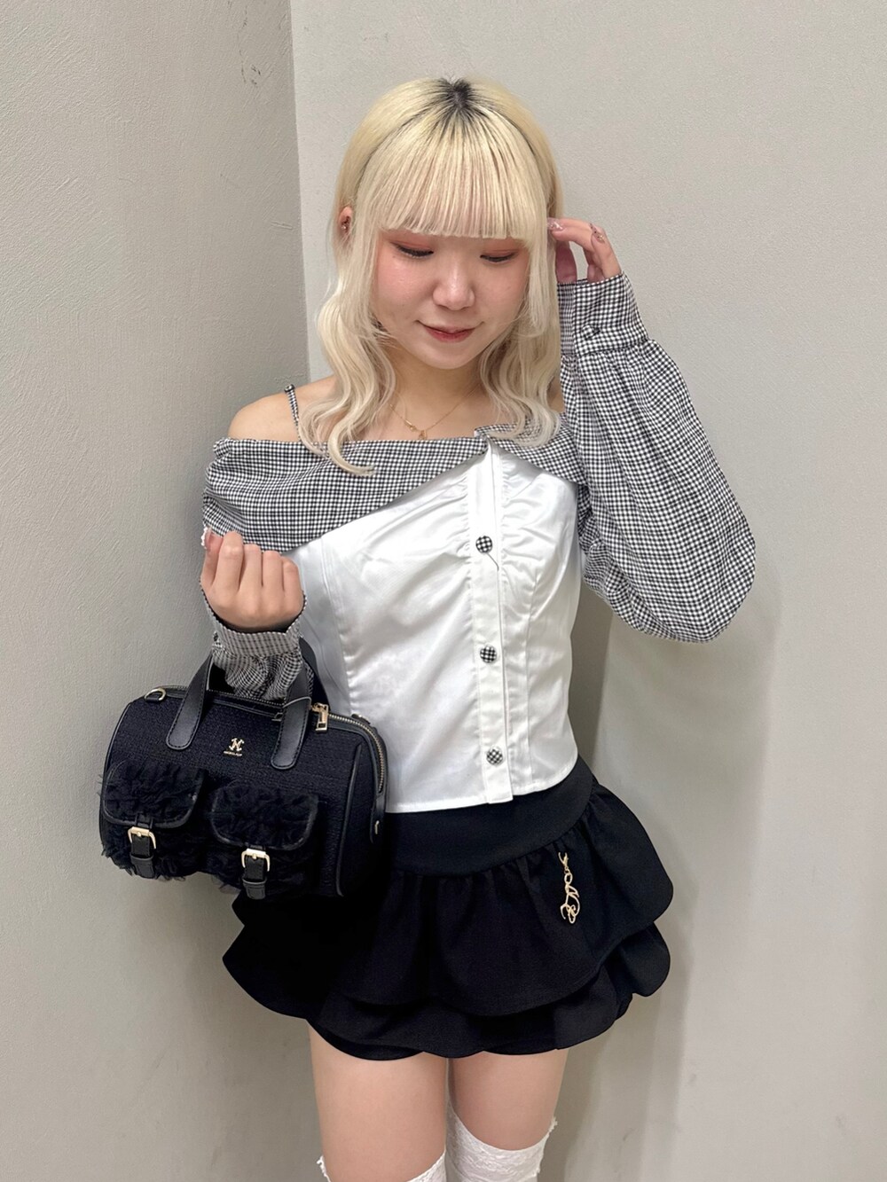 ブラック系のスカート、ブラック系のローファー、ブラック系のショルダーバッグを着用したレディースの春コーディネートの4枚目の写真