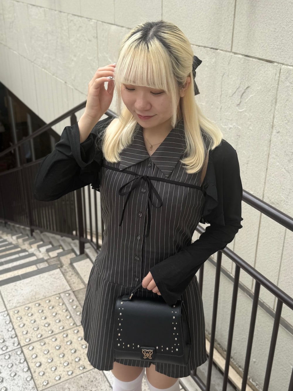 ブラック系のショルダーバッグ、ブラック系のカーディガン/ボレロ、グレー系のワンピースを着用したレディースの夏コーディネートの4枚目の写真