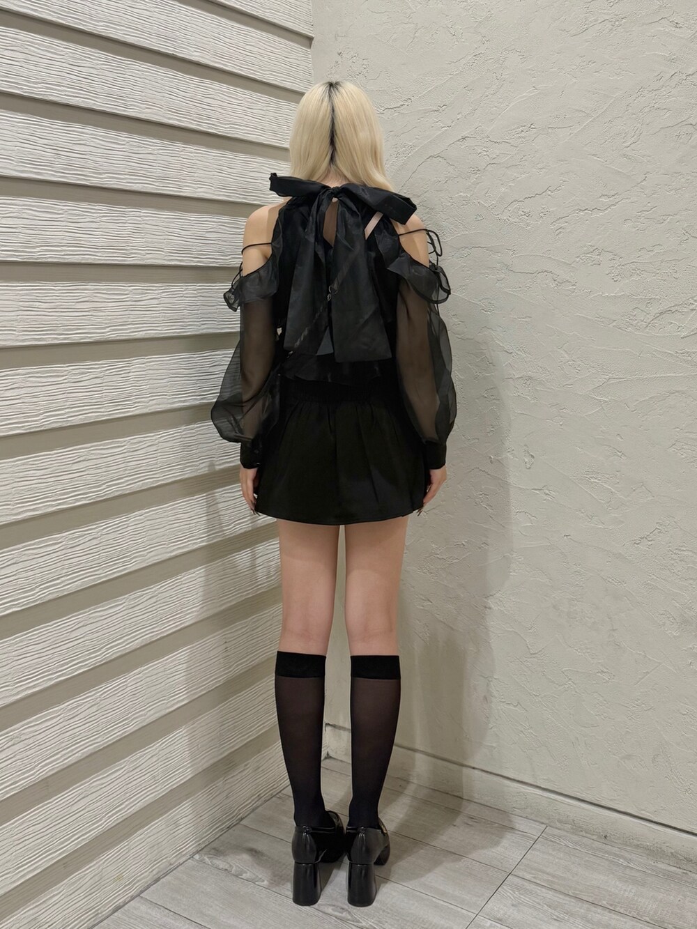 ブラック系のスカート、ブラック系のシャツ/ブラウス、ピンク系のショルダーバッグを着用したレディースの秋コーディネートの3枚目の写真