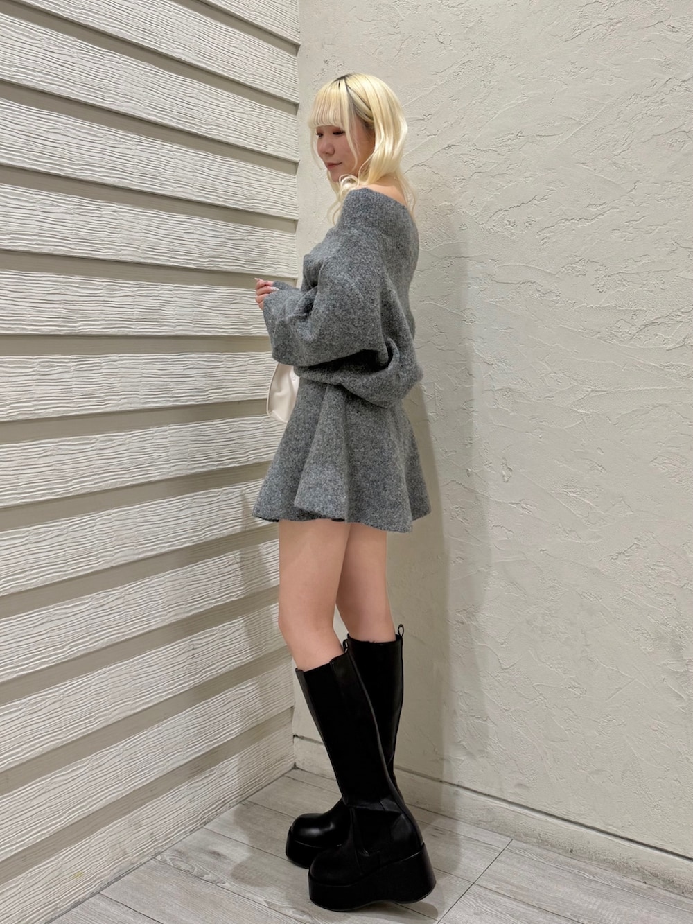 グレー系のセットアップ、ピンク系のトートバッグ、ブラック系のブーツを着用したレディースの冬コーディネートの2枚目の写真