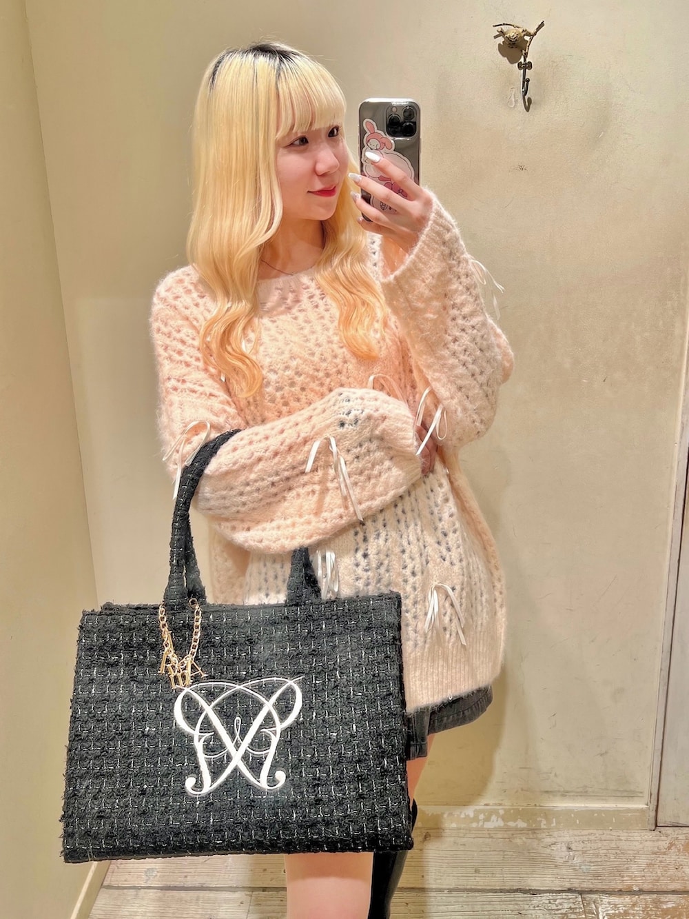 ブラック系のトートバッグ、ブラック系のブーツ、ピンク系のニット/セーターを着用したレディースの秋コーディネートの2枚目の写真