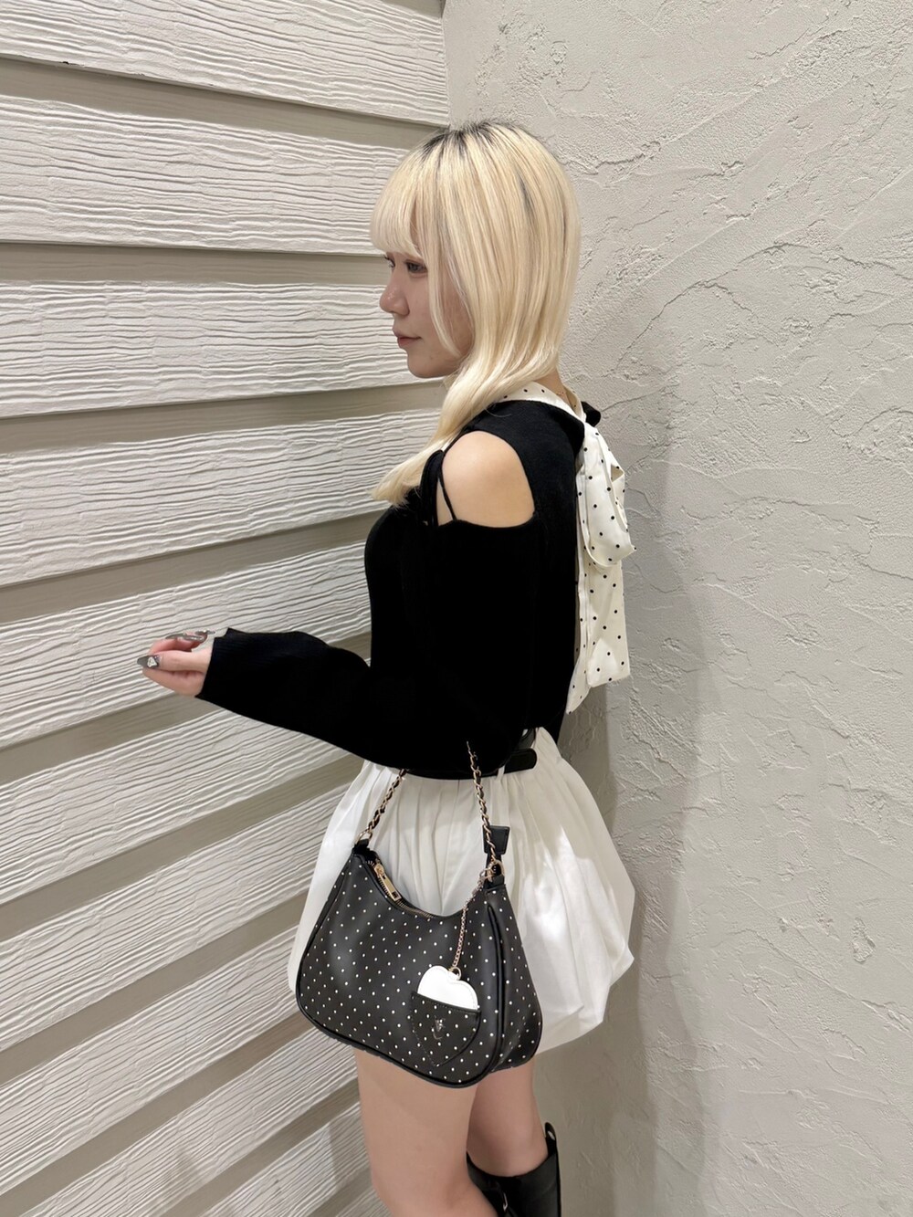 ブラック系のニット/セーター、その他のショルダーバッグ、ホワイト系のスカートを着用したレディースの秋コーディネートの5枚目の写真