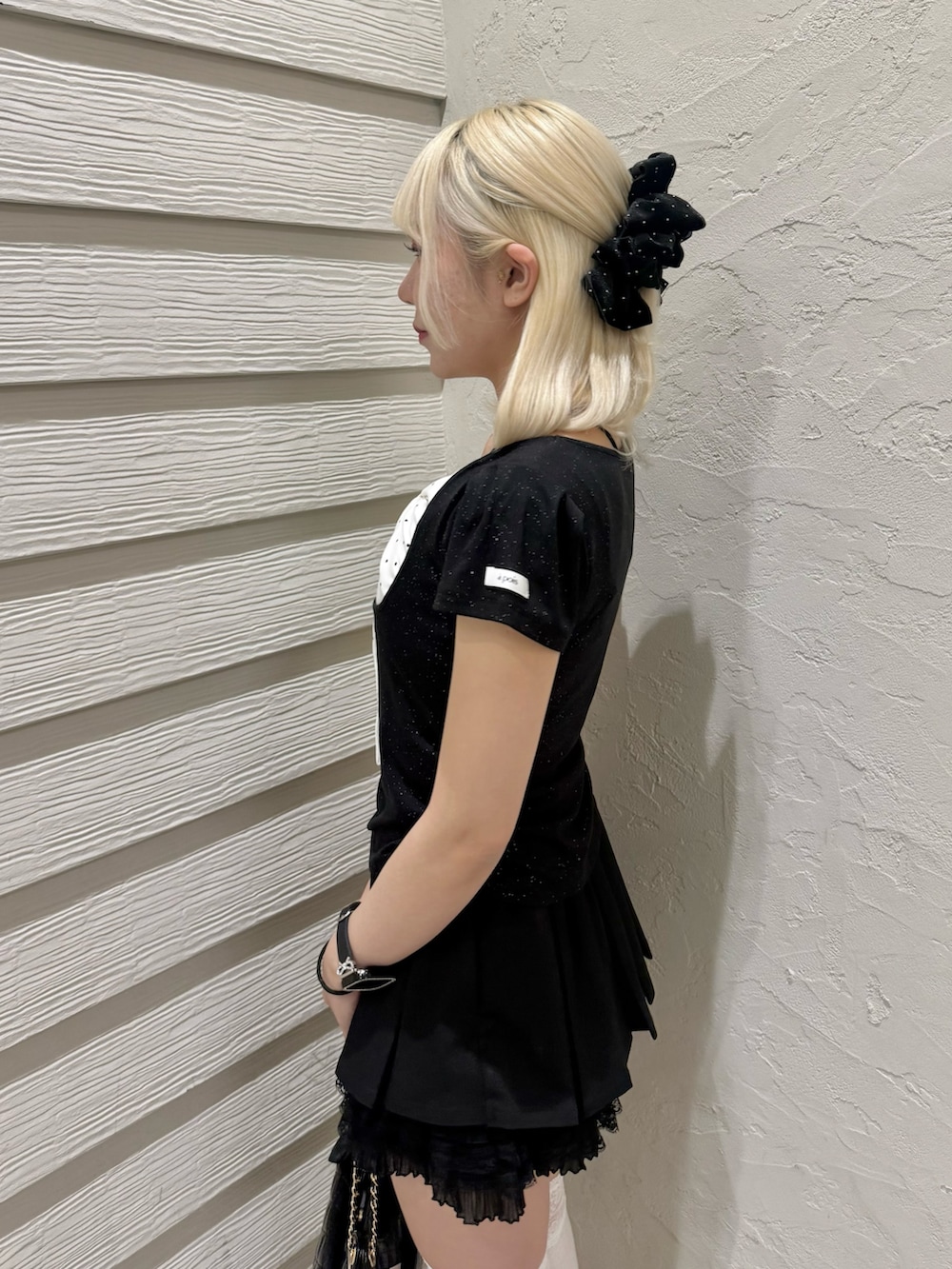 ブラック系のTシャツ/カットソー、ブラック系のショルダーバッグ、ブラック系のパンプスを着用したレディースの春コーディネートの5枚目の写真