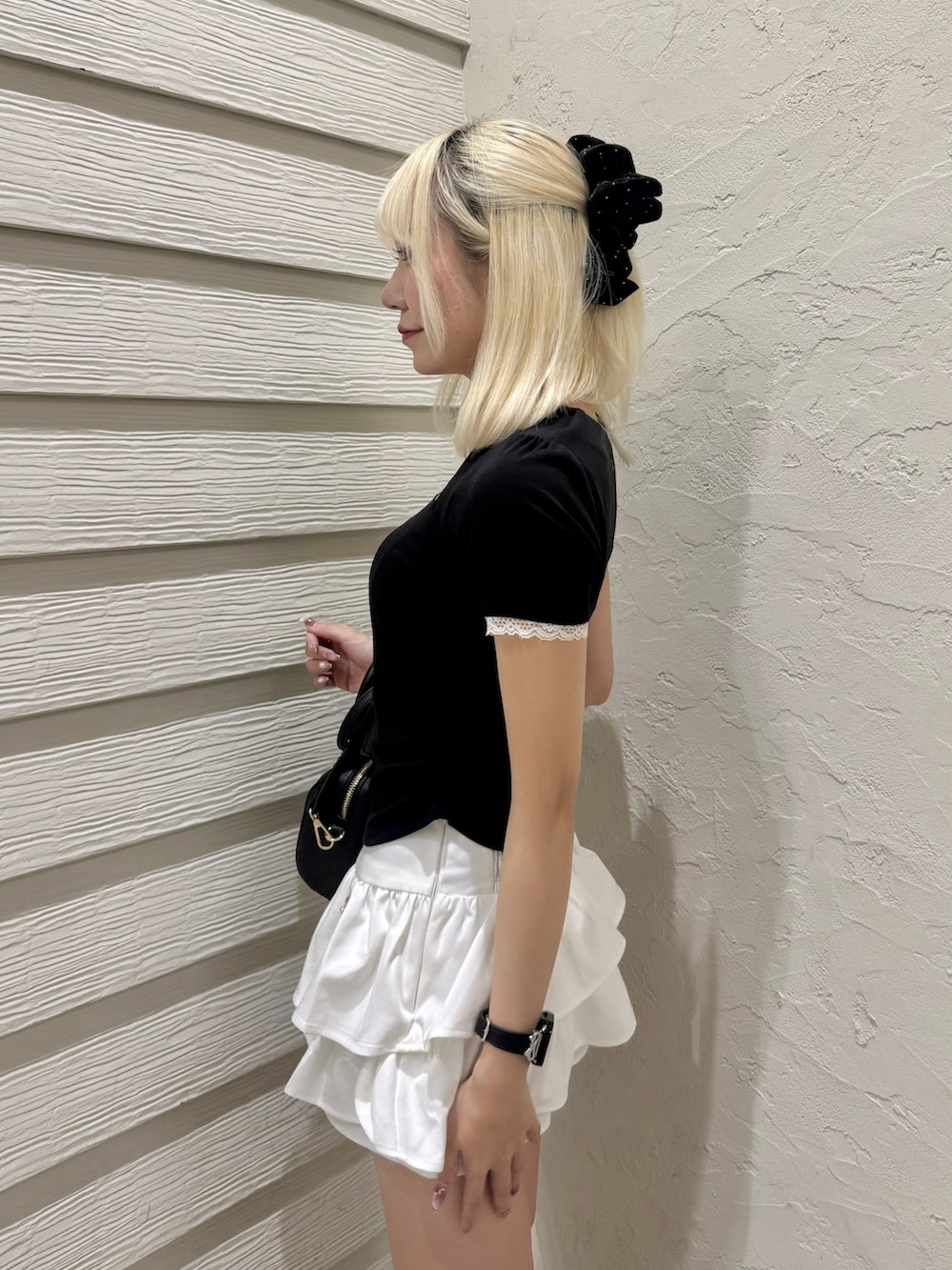 ブラック系のTシャツ/カットソー、ホワイト系のスカート、ブラック系のショルダーバッグを着用したレディースの夏コーディネートの5枚目の写真