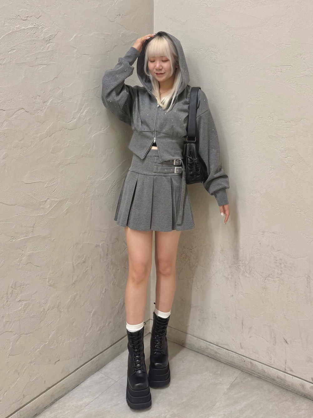 ブラック系のショルダーバッグ、グレー系のパーカー、グレー系のスカートを着用したレディースの秋コーディネートの2枚目の写真