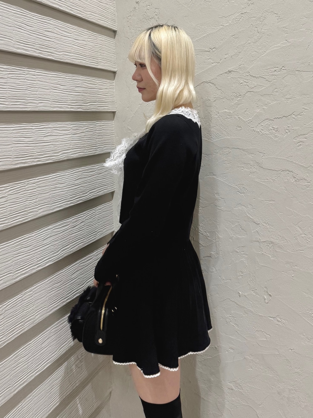 ブラック系のセットアップ、ブラック系のショルダーバッグ、ブラック系のローファーを着用したレディースの冬コーディネートの5枚目の写真