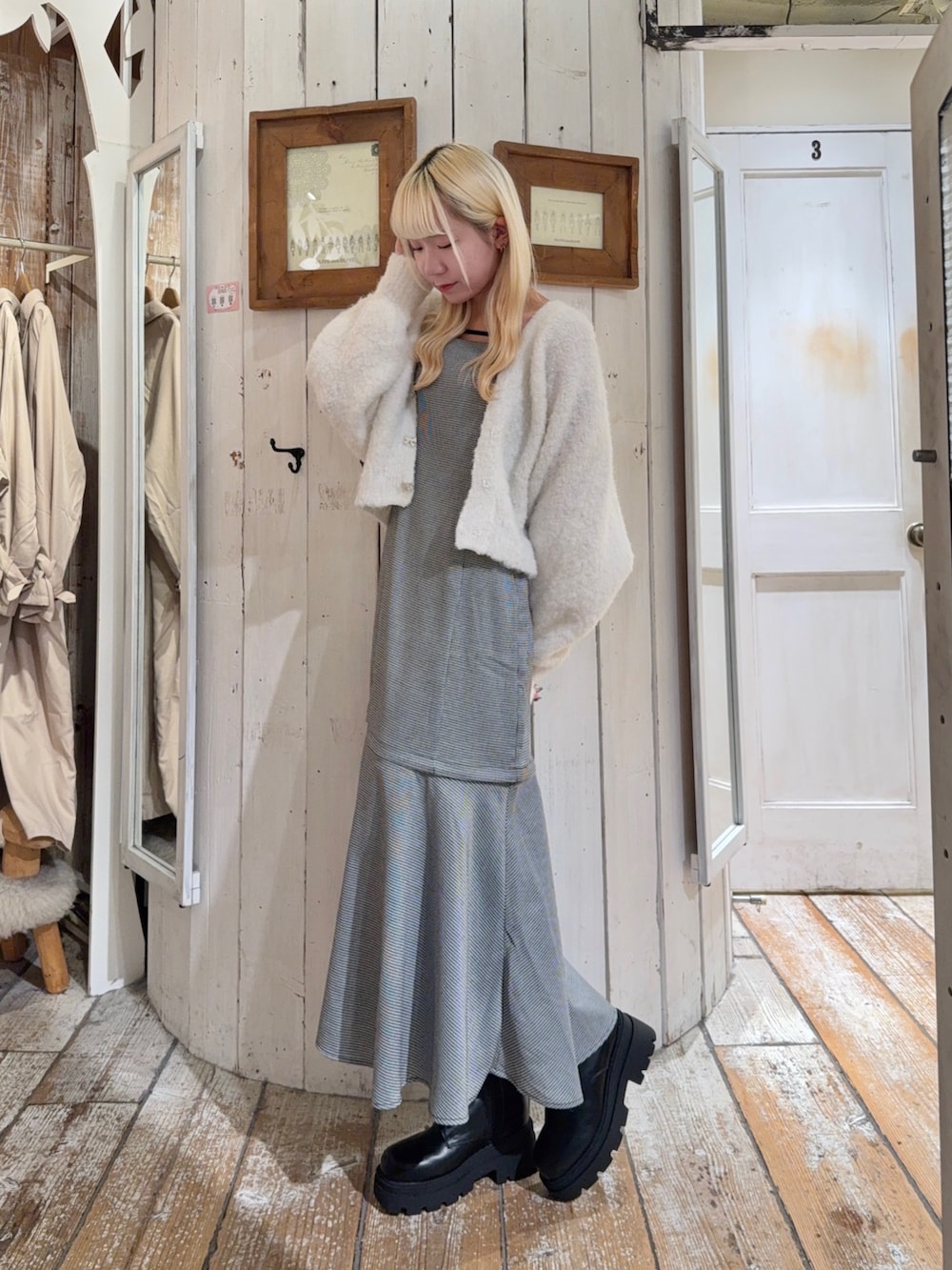 ブラック系のワンピース、ホワイト系のカーディガン/ボレロ、ブラック系のショルダーバッグを着用したレディースの秋コーディネートの3枚目の写真