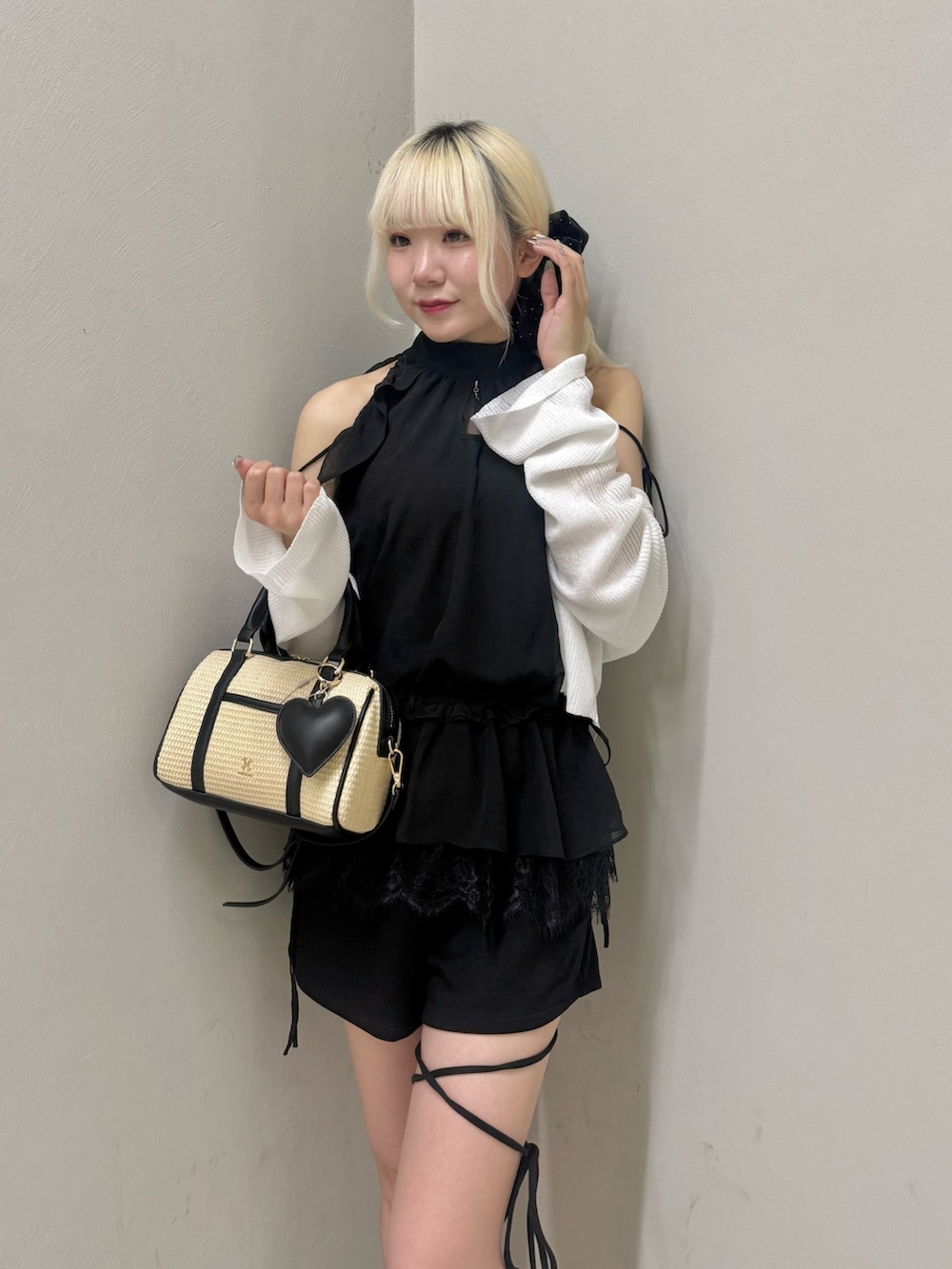 ブラック系のショルダーバッグ、ブラック系のシャツ/ブラウス、ホワイト系のカーディガン/ボレロを着用したレディースの夏コーディネートの6枚目の写真