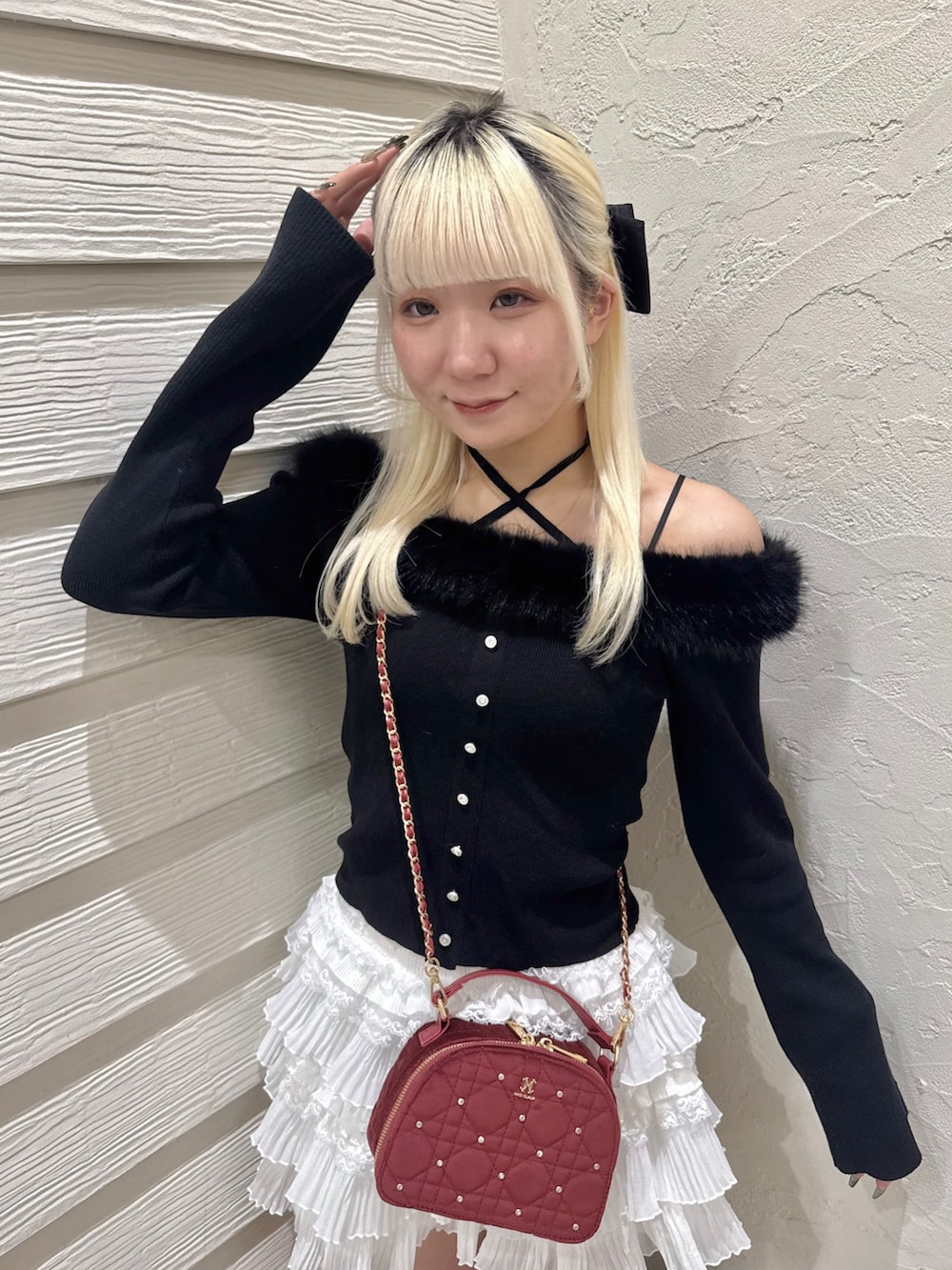 ブラック系のニット/セーター、ホワイト系のスカート、ブラック系のブーツを着用したレディースの秋コーディネートの4枚目の写真