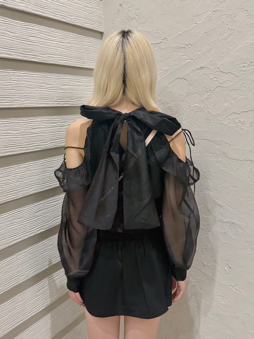 ブラック系のスカート、ブラック系のシャツ/ブラウス、ピンク系のショルダーバッグを着用したレディースの秋コーディネートの6枚目の写真