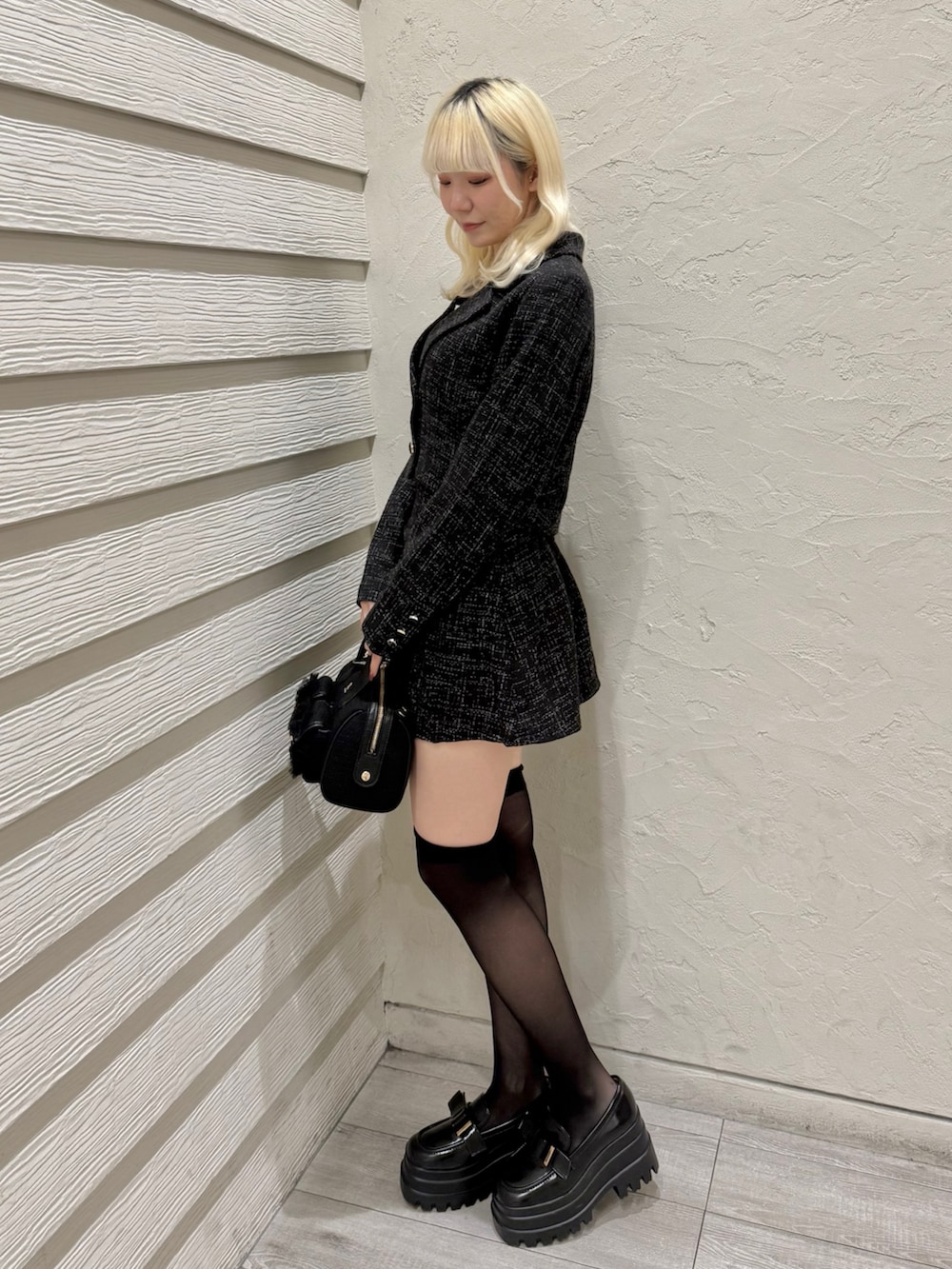 ブラック系のショルダーバッグ、ブラック系のスカート、ブラック系のテーラードジャケットを着用したレディースの冬コーディネートの2枚目の写真