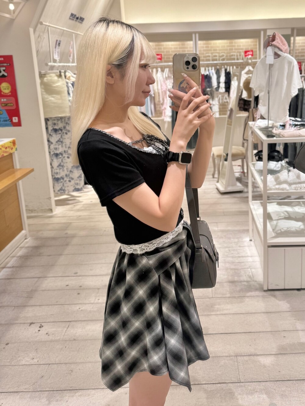 グレー系のショルダーバッグ、ブラック系のスカート、ブラック系のTシャツ/カットソーを着用したレディースの夏コーディネートの3枚目の写真