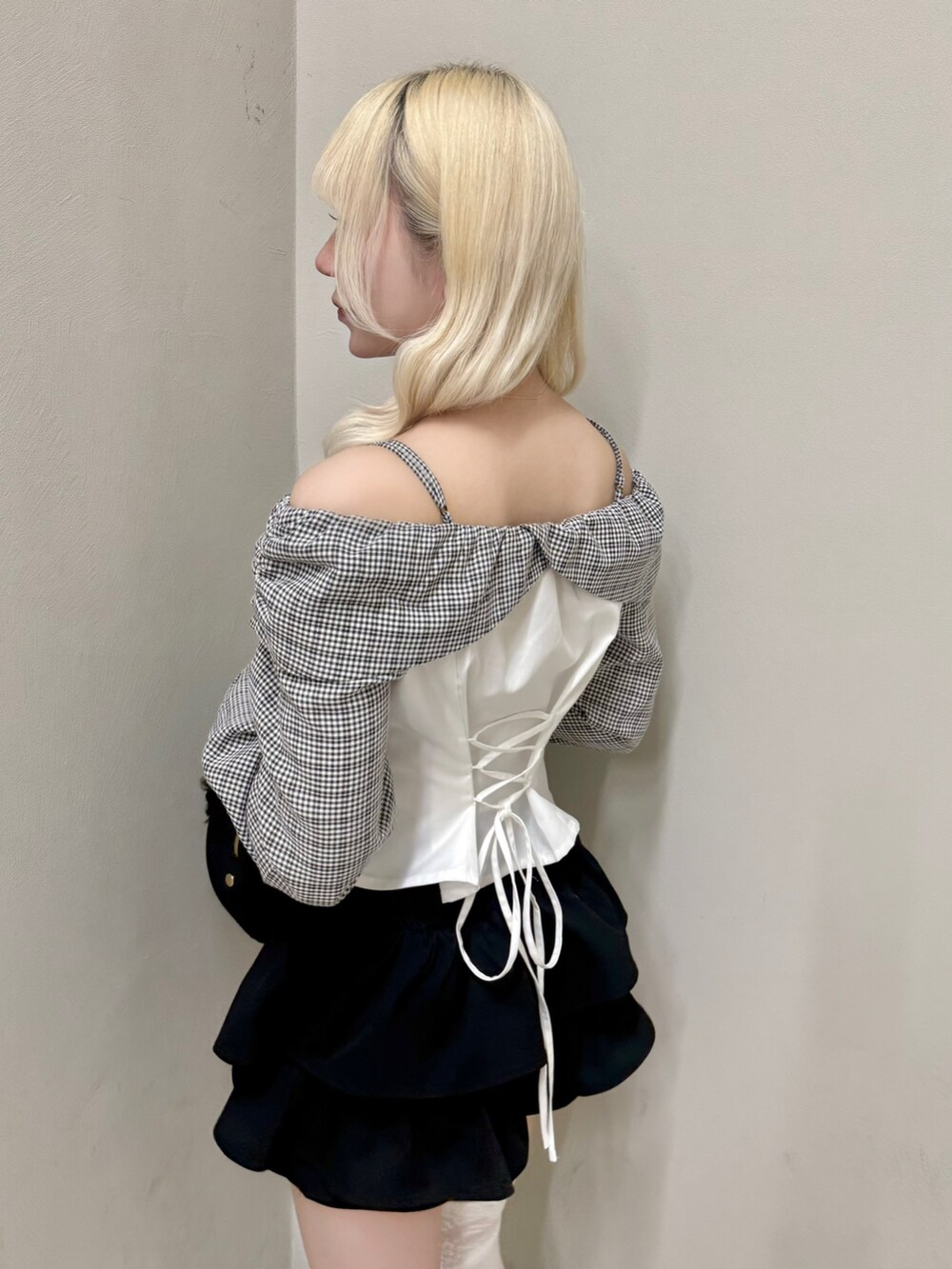 ブラック系のスカート、ブラック系のローファー、ブラック系のショルダーバッグを着用したレディースの春コーディネートの5枚目の写真