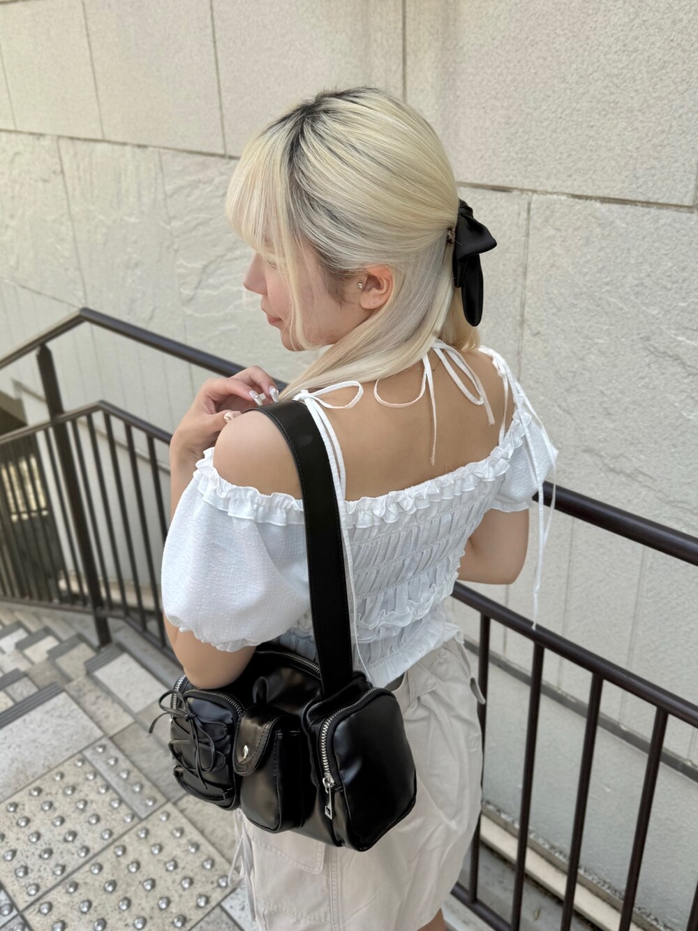 ブラック系のその他シューズ、ホワイト系のシャツ/ブラウス、ブラック系のショルダーバッグを着用したレディースの春コーディネートの5枚目の写真