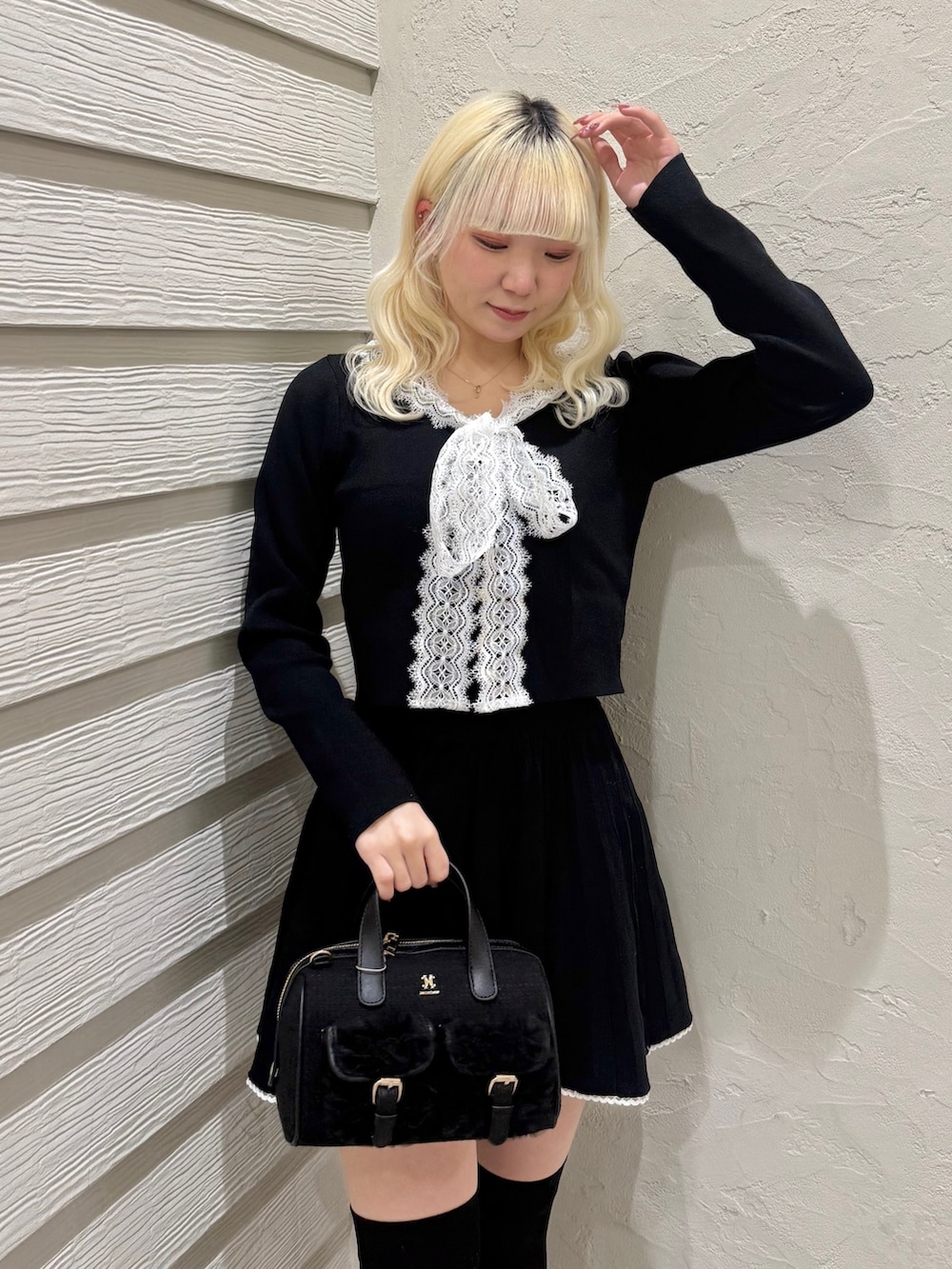 ブラック系のセットアップ、ブラック系のショルダーバッグ、ブラック系のローファーを着用したレディースの冬コーディネートの4枚目の写真