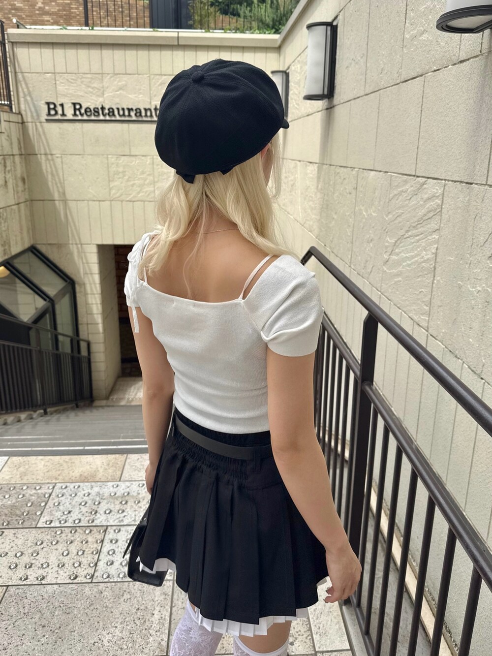 ブラック系のスカート、ホワイト系のTシャツ/カットソー、ブラック系のショルダーバッグを着用したレディースの春コーディネートの4枚目の写真