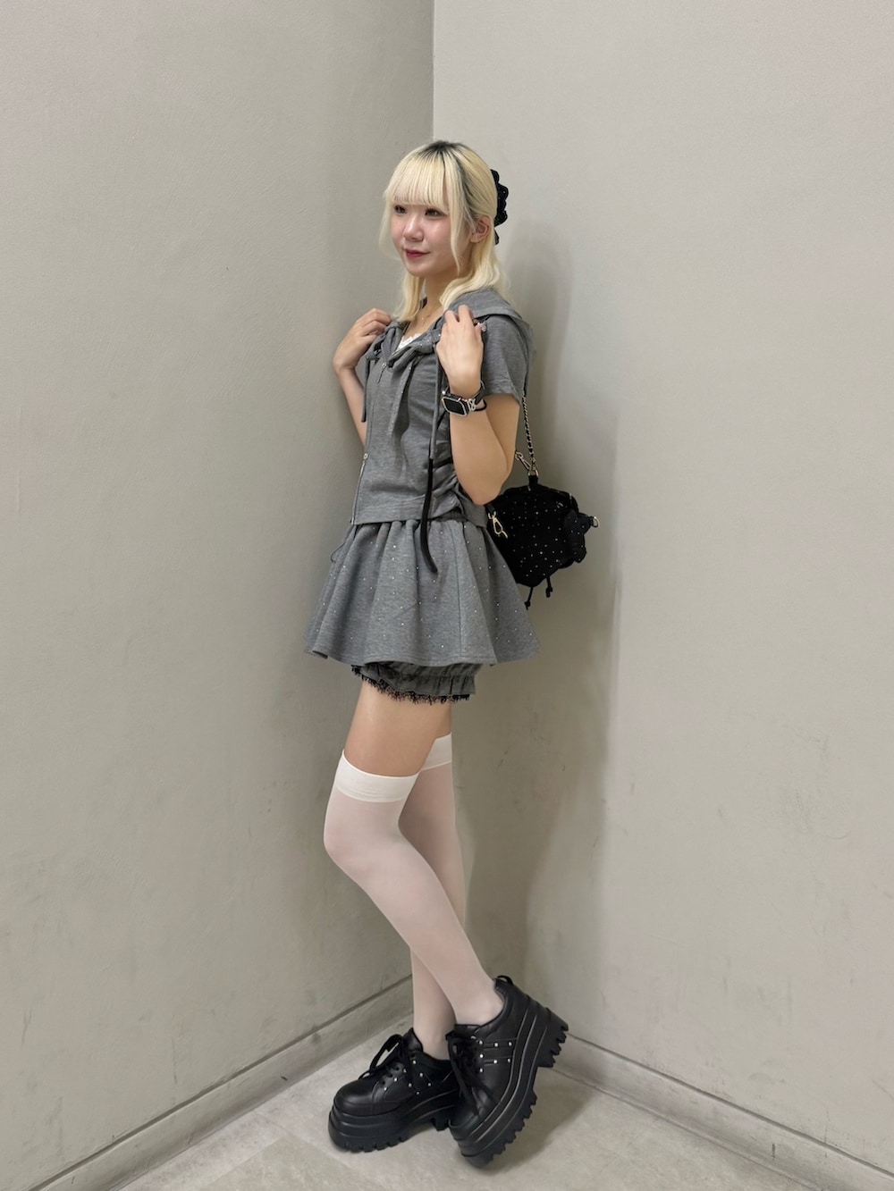ブラック系のスニーカー、グレー系のスカート、グレー系のパーカーを着用したレディースの夏コーディネートの2枚目の写真