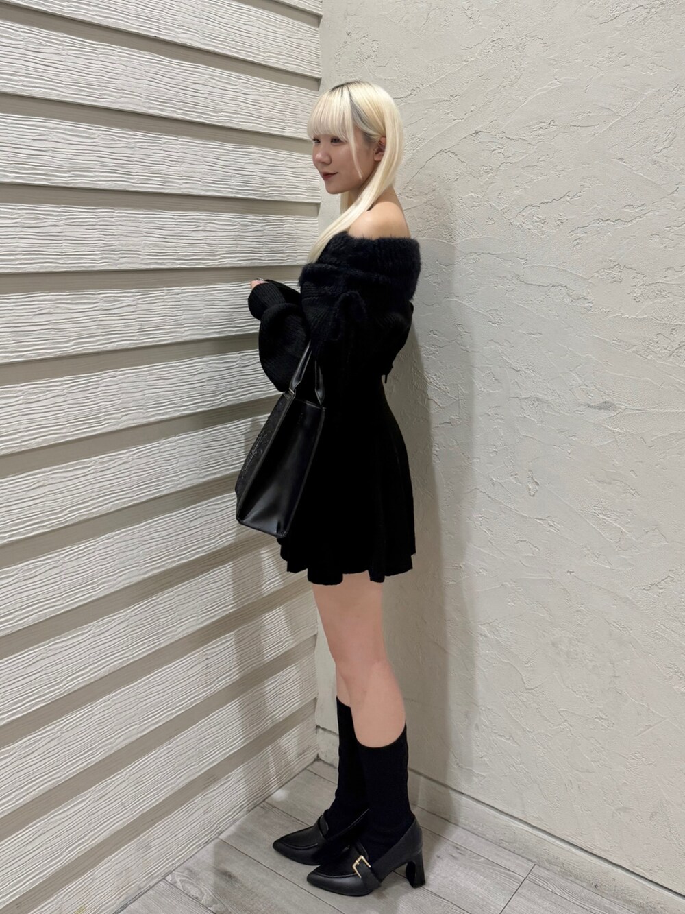 ブラック系のワンピース、ブラック系のトートバッグ、ブラック系のブーツを着用したレディースの秋コーディネートの2枚目の写真