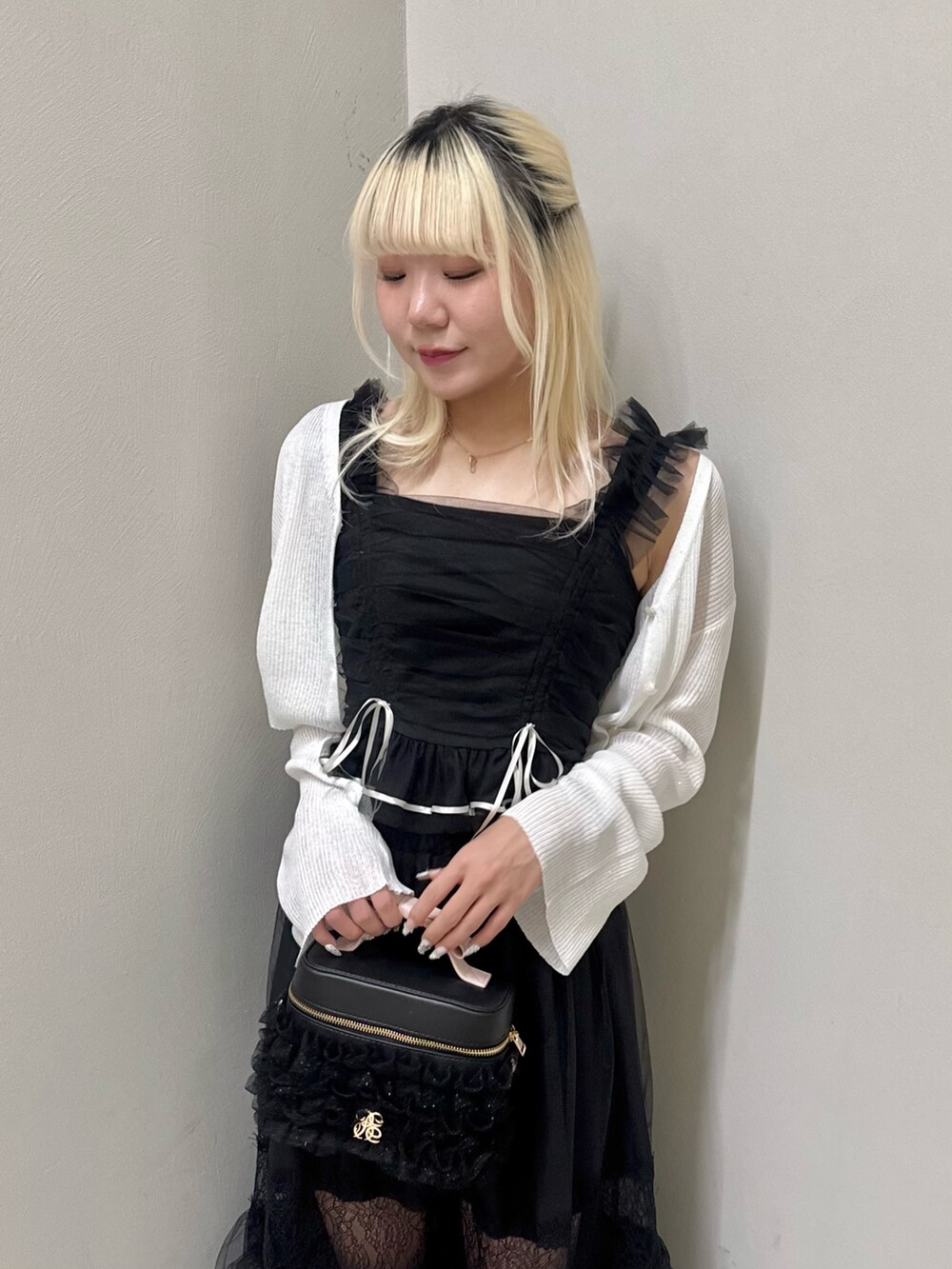 ブラック系のスカート、ブラック系のショルダーバッグ、ブラック系のサンダルを着用したレディースの春コーディネートの5枚目の写真