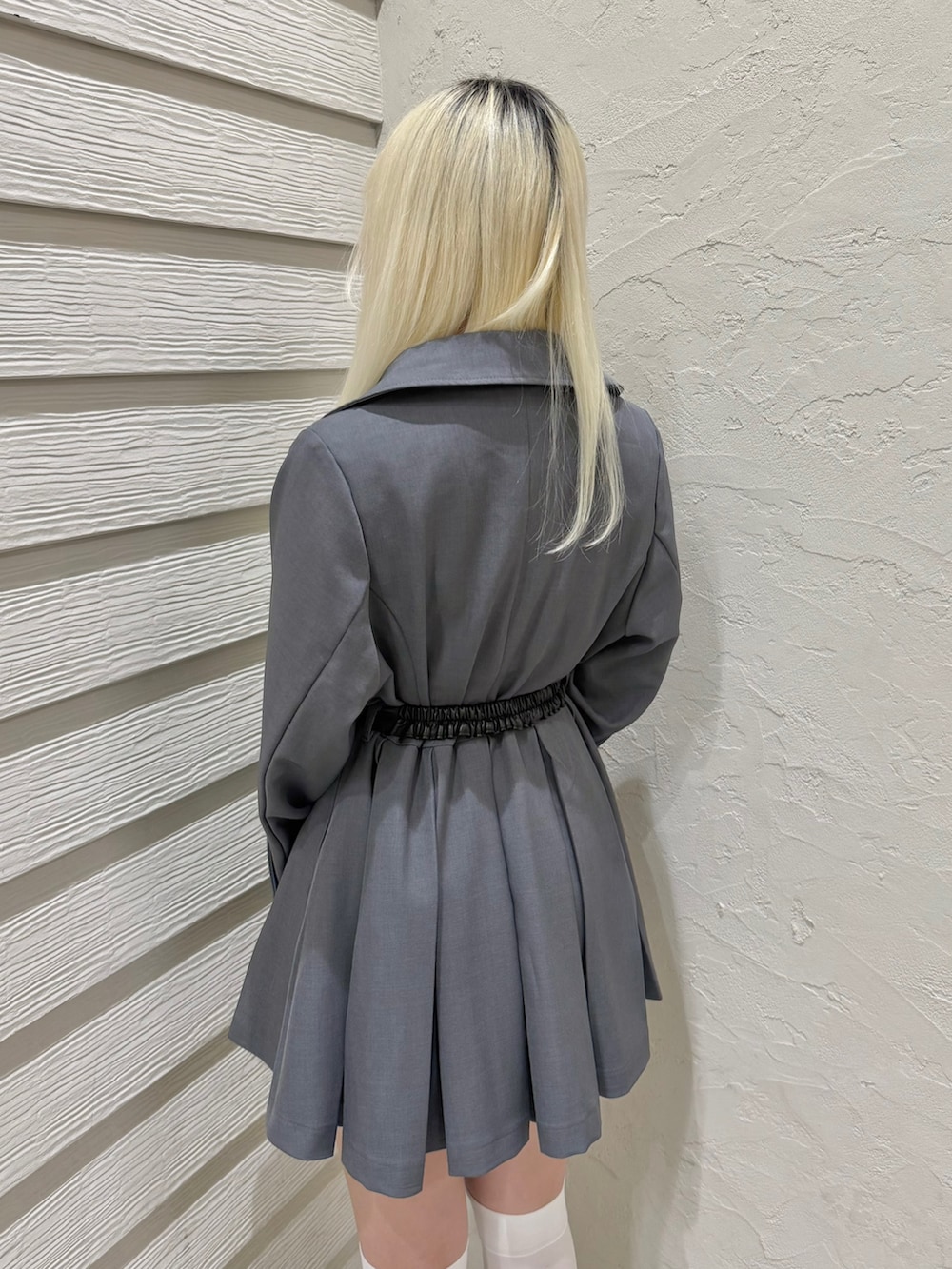 グレー系のトレンチコート、ホワイト系のTシャツ/カットソー、ブラック系のショルダーバッグを着用したレディースの春コーディネートの6枚目の写真