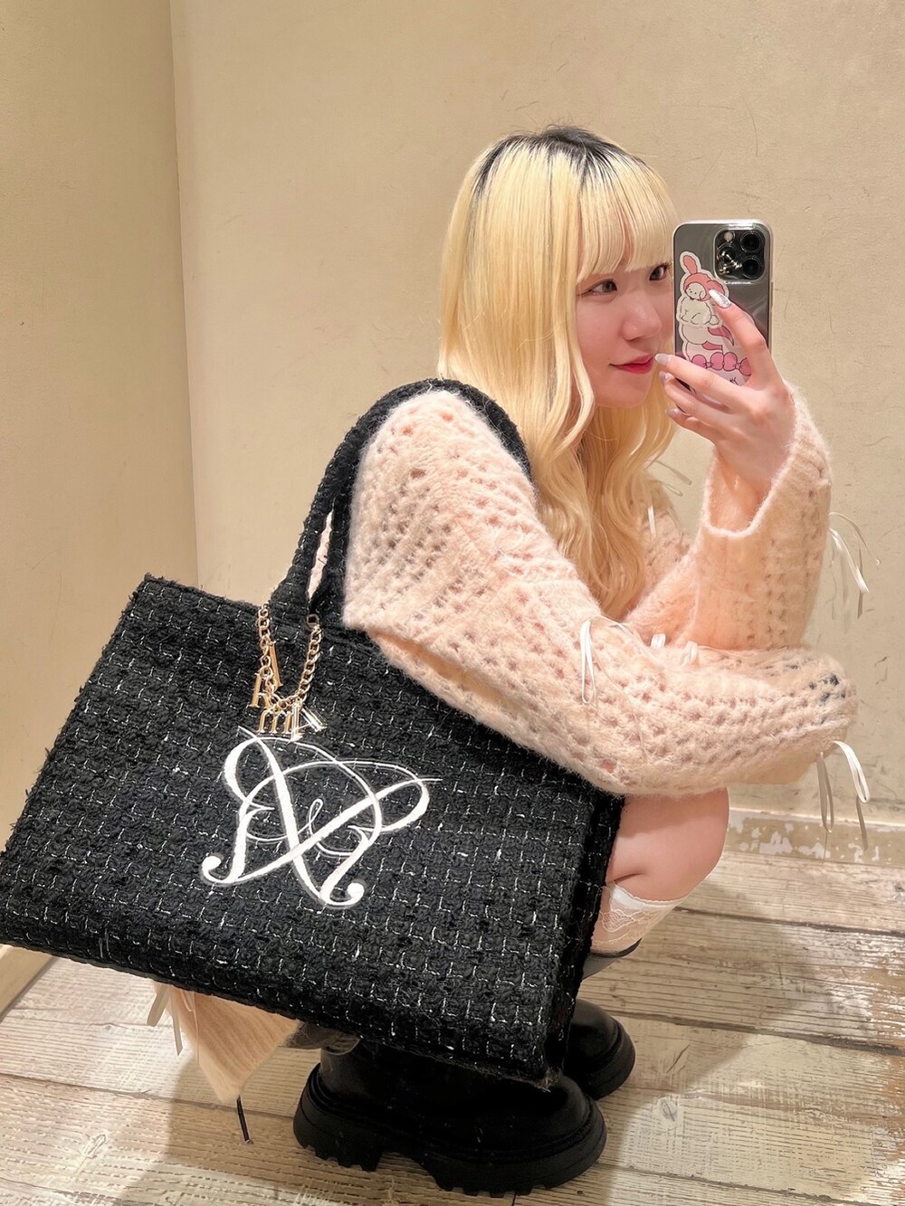 ブラック系のトートバッグ、ブラック系のブーツ、ピンク系のニット/セーターを着用したレディースの秋コーディネートの3枚目の写真