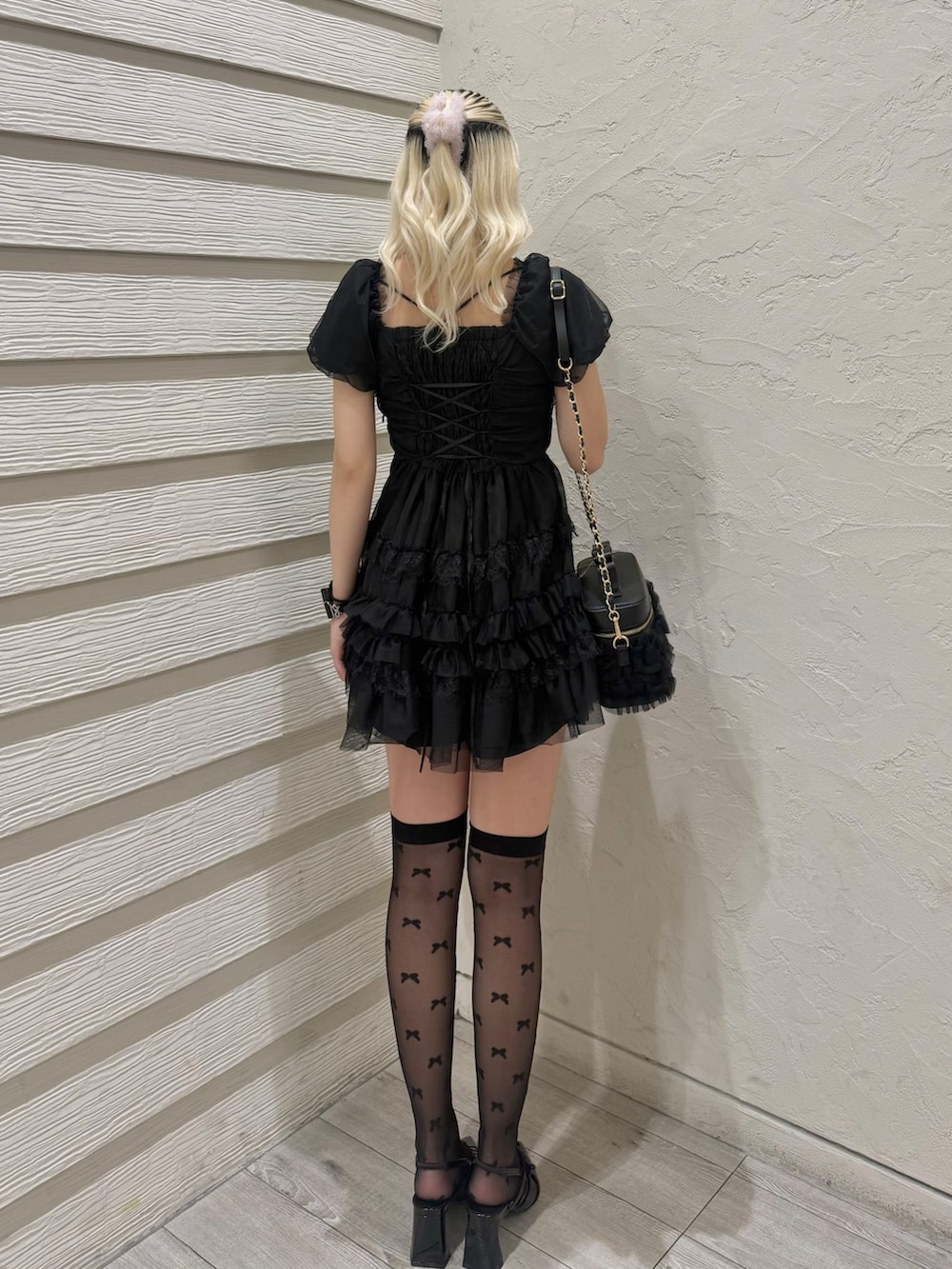 ブラック系のワンピース、ブラック系のショルダーバッグ、ブラック系のパンプスを着用したレディースの春コーディネートの4枚目の写真