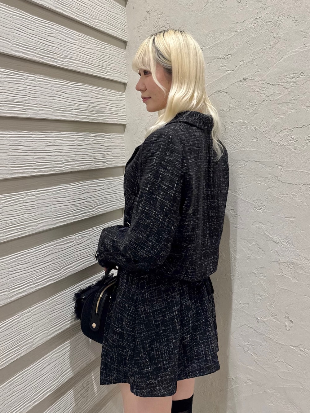 ブラック系のショルダーバッグ、ブラック系のスカート、ブラック系のテーラードジャケットを着用したレディースの冬コーディネートの5枚目の写真