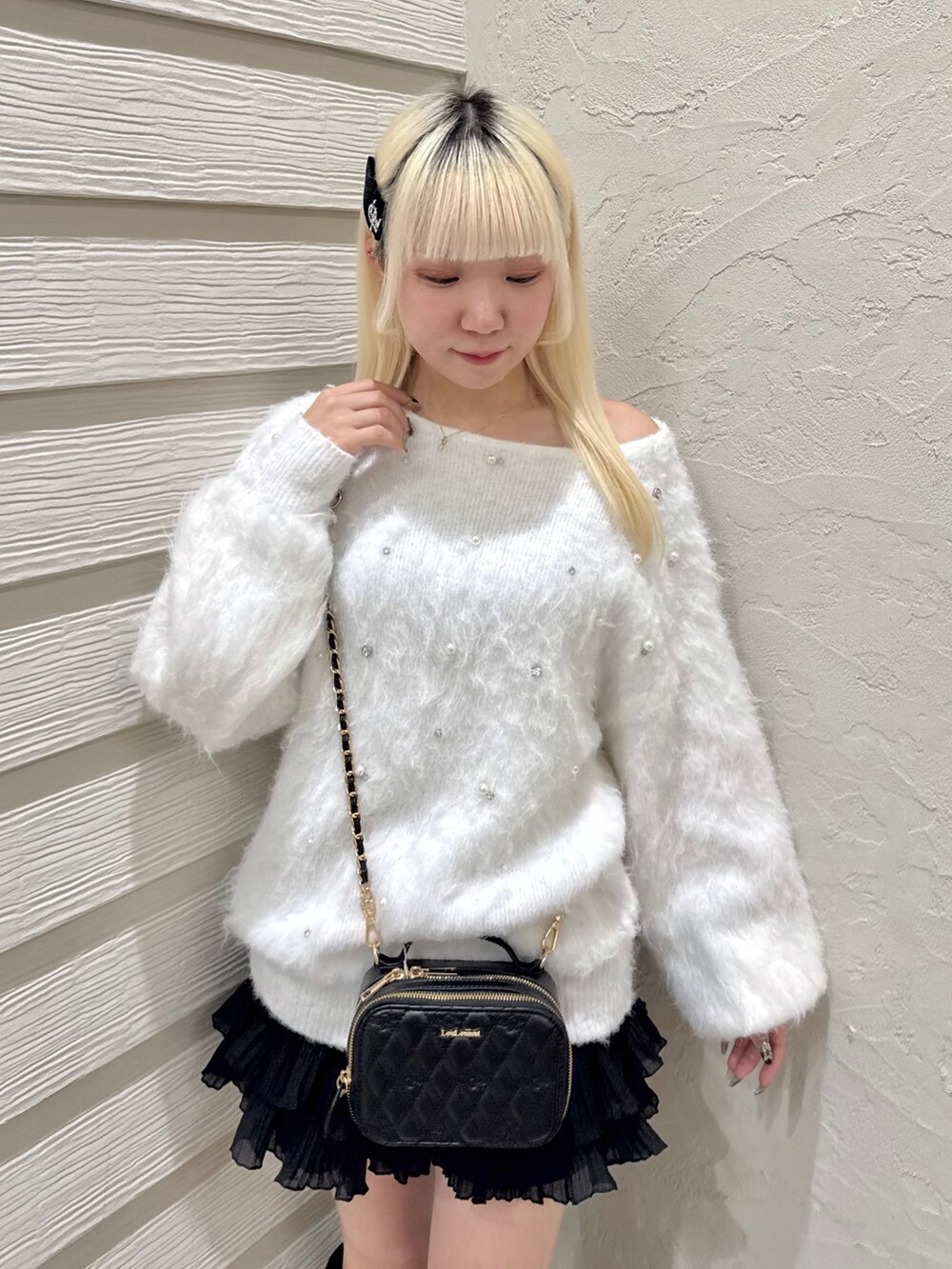 ホワイト系のニット/セーター、ブラック系のスカート、ブラック系のショルダーバッグを着用したレディースの秋コーディネートの4枚目の写真