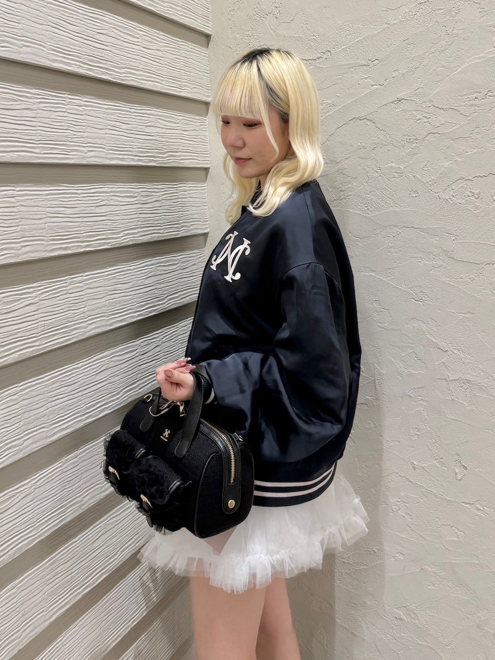 ブルー系のスカジャン、ホワイト系のスカート、ブラック系のスニーカーを着用したレディースの冬コーディネートの5枚目の写真