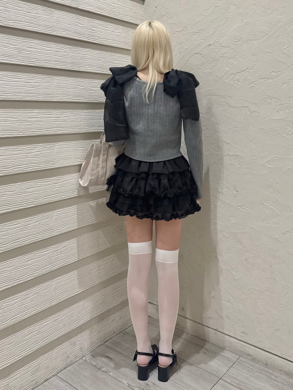 グレー系のカーディガン/ボレロ、ブラック系のスカート、ブラック系のパンプスを着用したレディースの春コーディネートの2枚目の写真