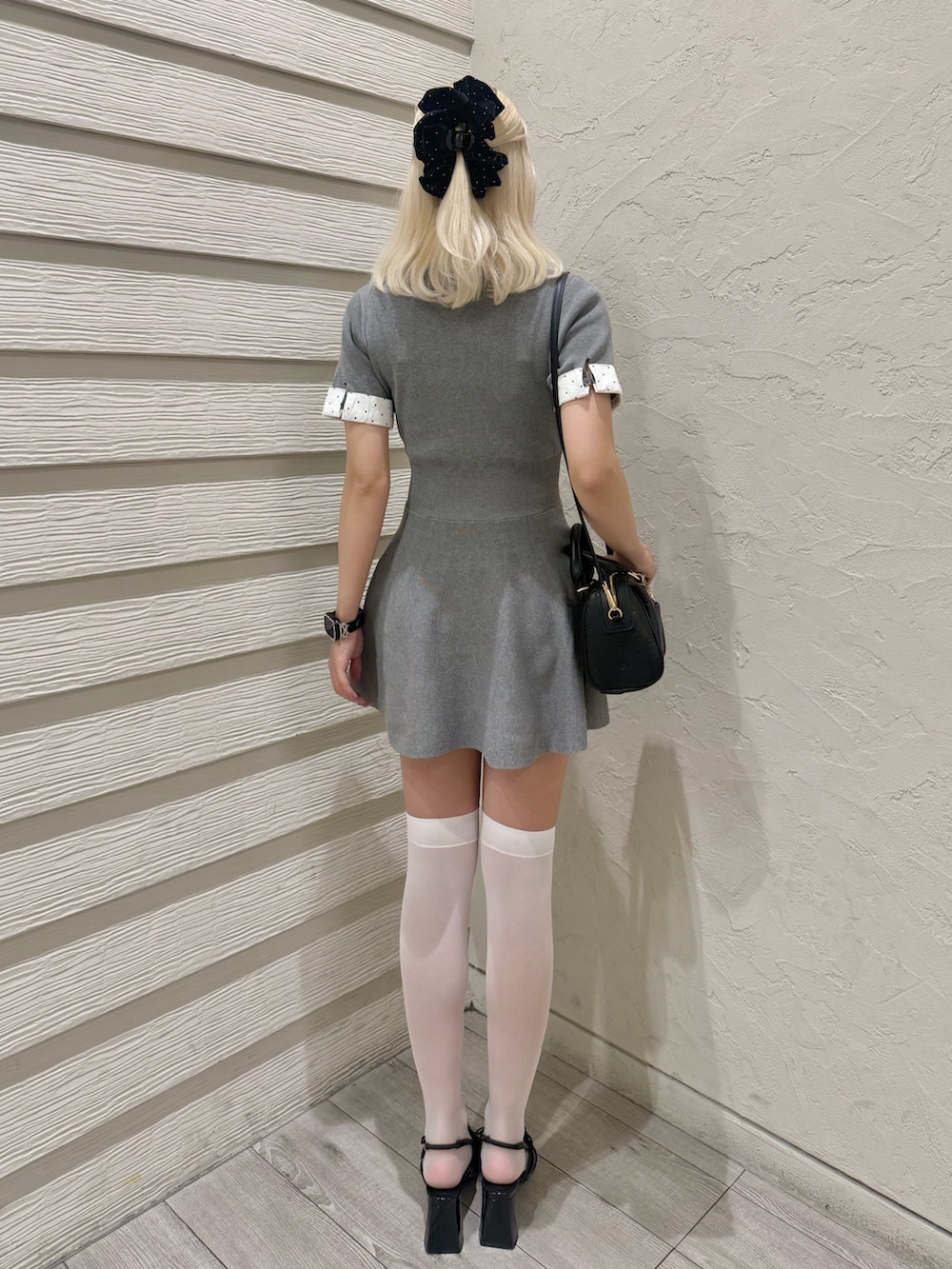 ブラック系のパンプス、ブラック系のショルダーバッグ、グレー系のワンピースを着用したレディースの夏コーディネートの3枚目の写真