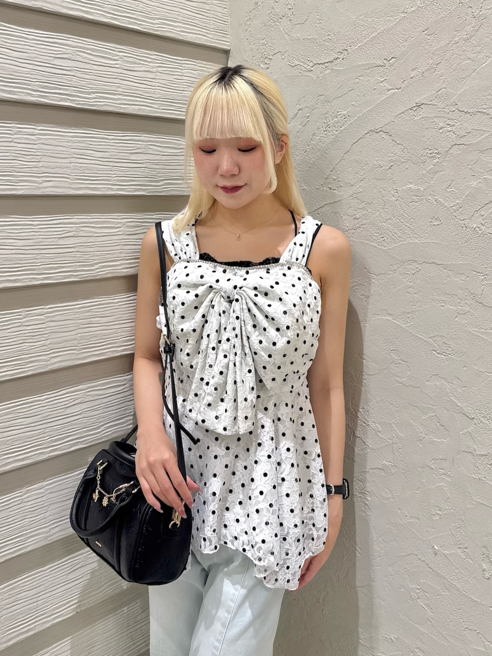 ブラック系のショルダーバッグ、ブルー系のデニムパンツ、ブラック系のサンダルを着用したレディースの夏コーディネートの9枚目の写真