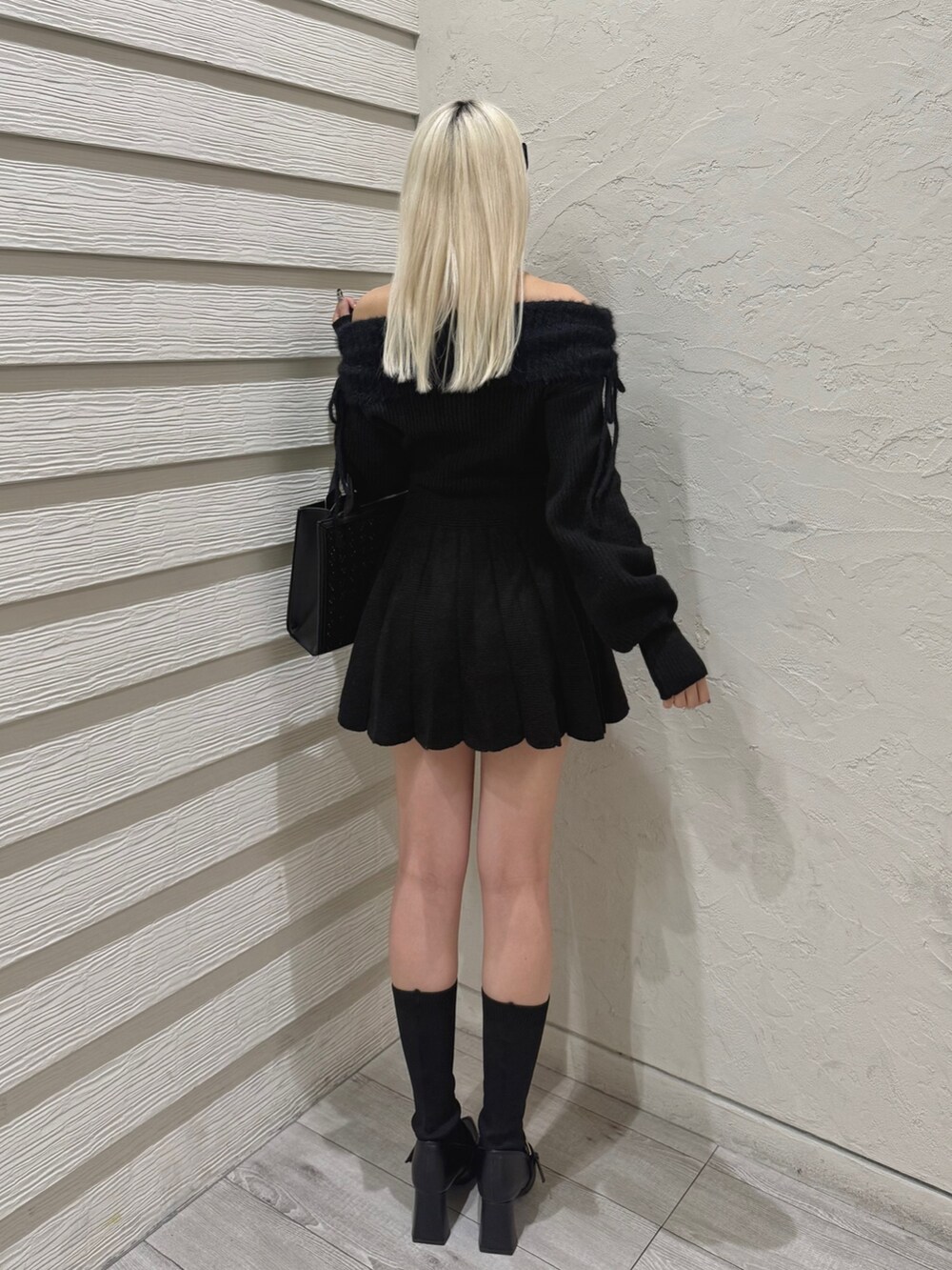 ブラック系のワンピース、ブラック系のトートバッグ、ブラック系のブーツを着用したレディースの秋コーディネートの3枚目の写真