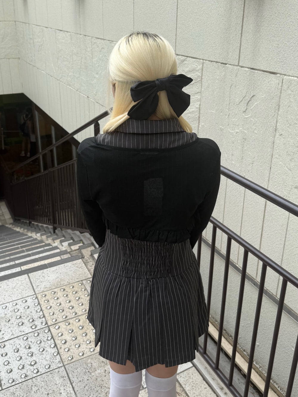 ブラック系のショルダーバッグ、ブラック系のカーディガン/ボレロ、グレー系のワンピースを着用したレディースの夏コーディネートの6枚目の写真