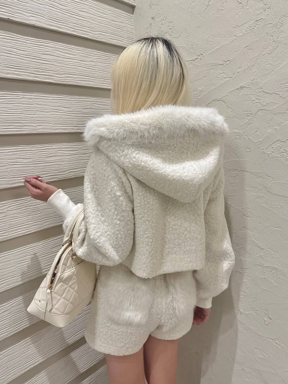 ホワイト系のその他パンツ、ホワイト系のその他アウター、ホワイト系のハンドバッグを着用したレディースの冬コーディネートの5枚目の写真