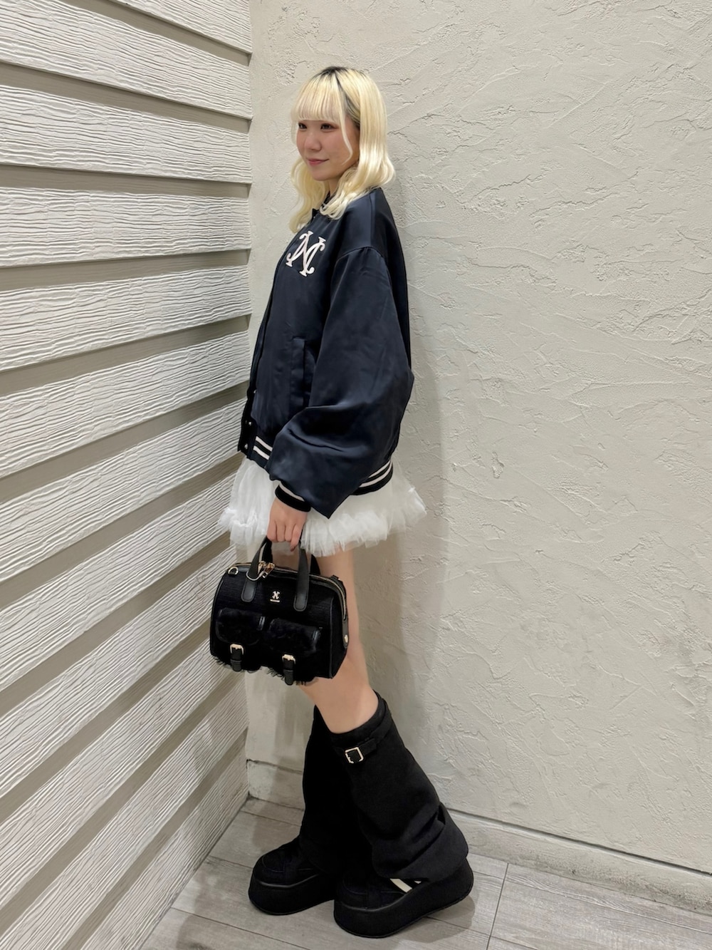 ブルー系のスカジャン、ホワイト系のスカート、ブラック系のスニーカーを着用したレディースの冬コーディネートの2枚目の写真