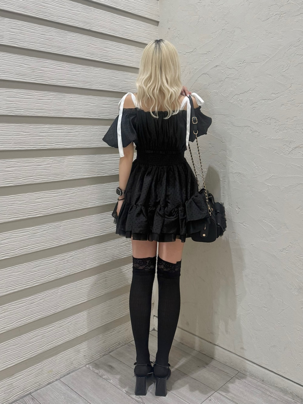 ブラック系のショルダーバッグ、ブラック系のパンプス、ブラック系のワンピースを着用したレディースの春コーディネートの3枚目の写真