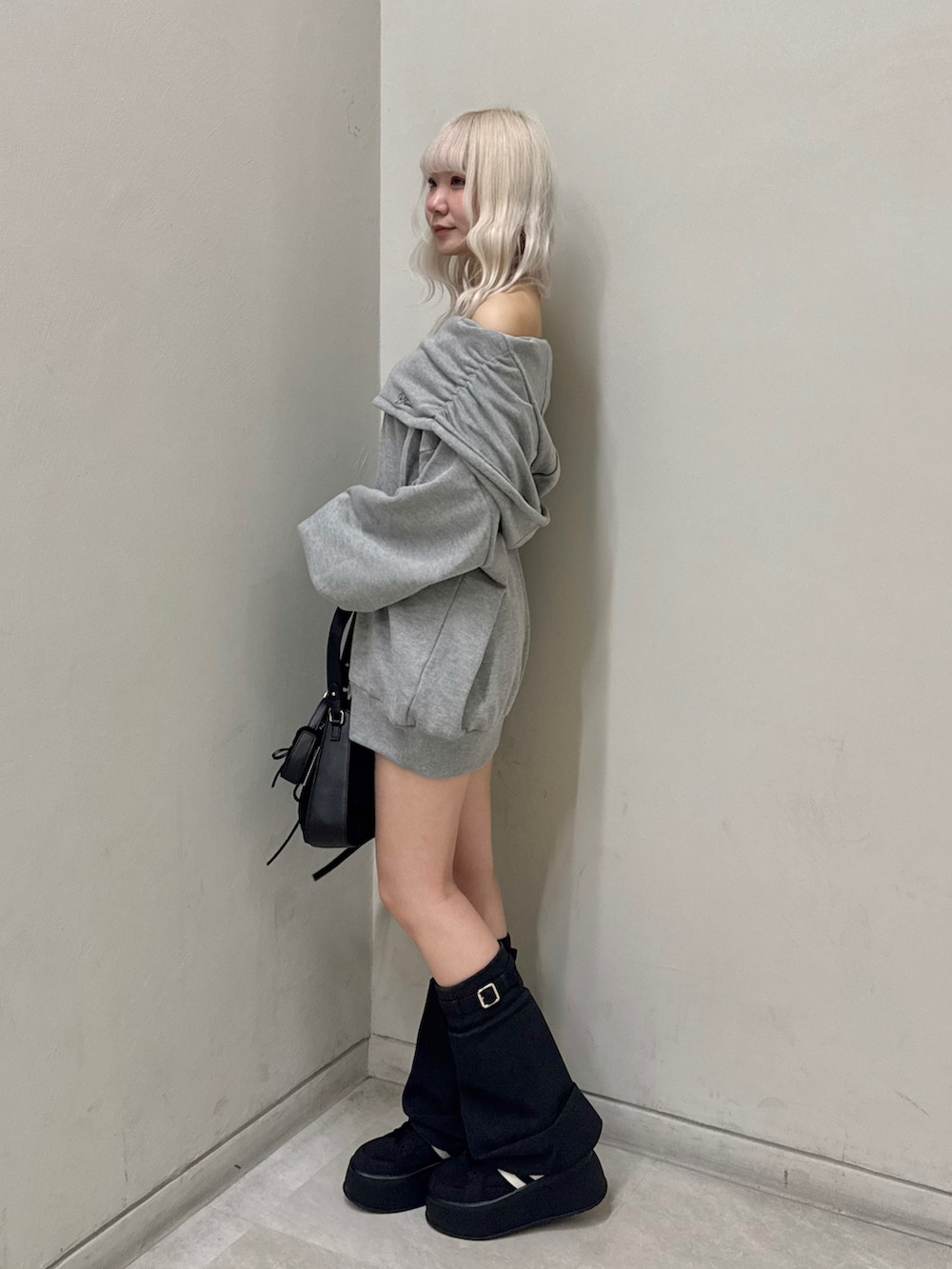 グレー系のパーカー、ブラック系のショルダーバッグ、ブラック系のスニーカーを着用したレディースの春コーディネートの2枚目の写真