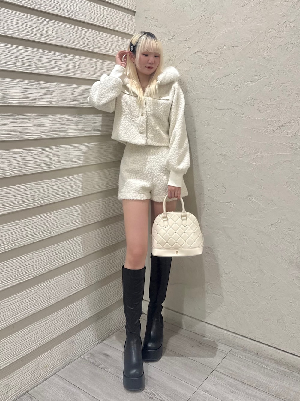 ホワイト系のその他パンツ、ホワイト系のその他アウター、ホワイト系のハンドバッグを着用したレディースの冬コーディネートの2枚目の写真