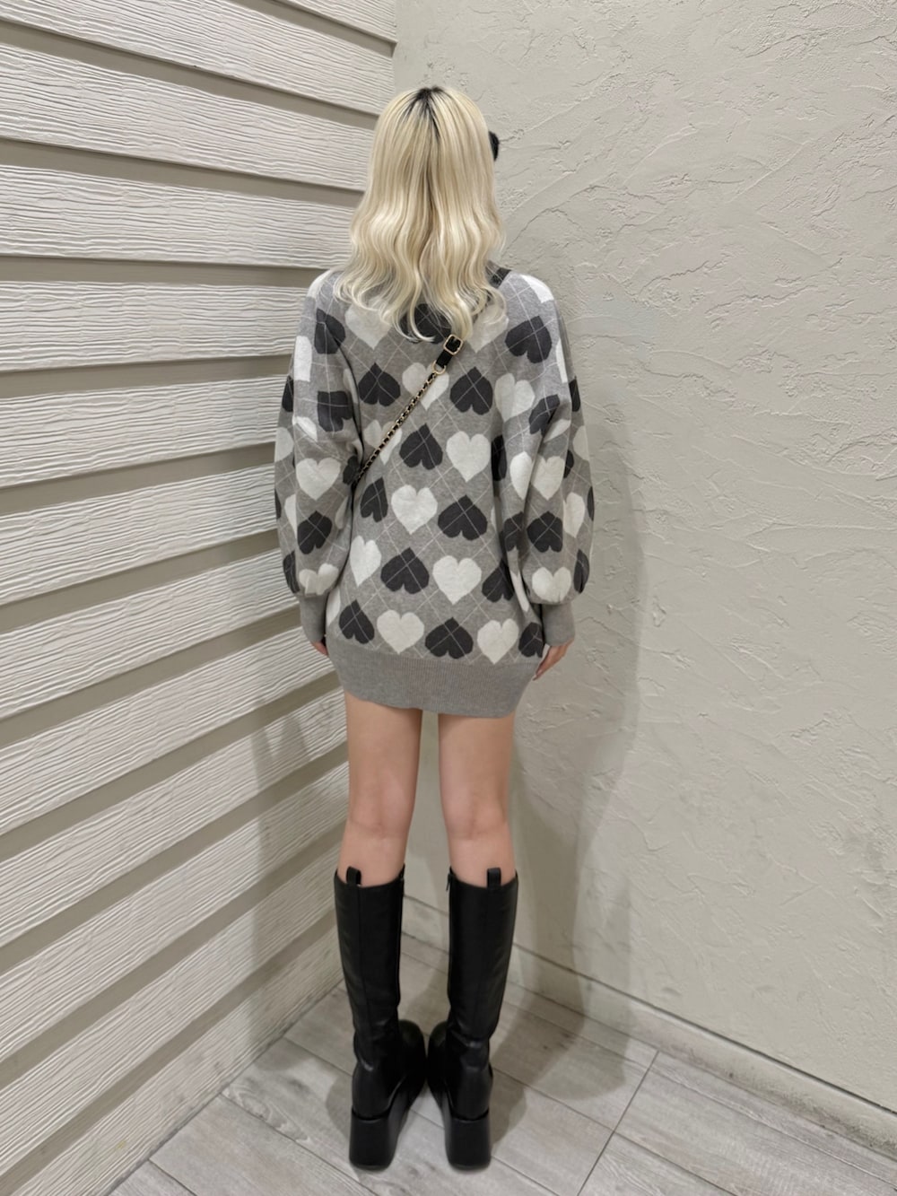 ブラック系のショルダーバッグ、グレー系のワンピース、ブラック系のブーツを着用したレディースの冬コーディネートの3枚目の写真