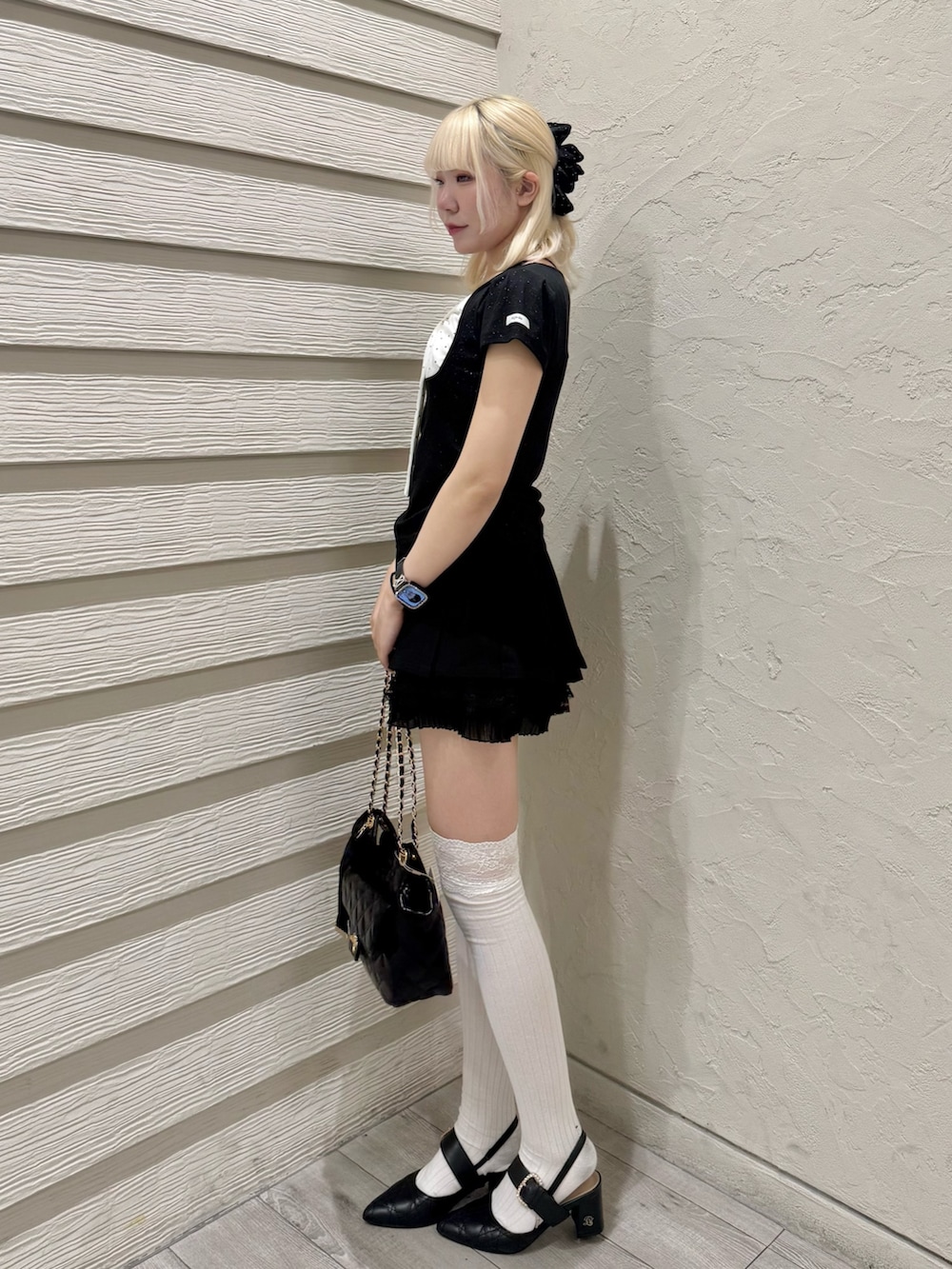 ブラック系のTシャツ/カットソー、ブラック系のショルダーバッグ、ブラック系のパンプスを着用したレディースの春コーディネートの2枚目の写真