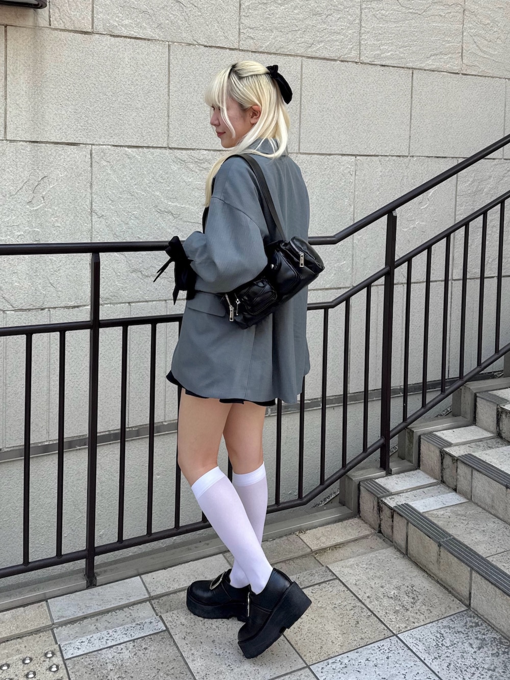 ブラック系のスカート、グレー系のその他アウター、ホワイト系のTシャツ/カットソーを着用したレディースの春コーディネートの2枚目の写真