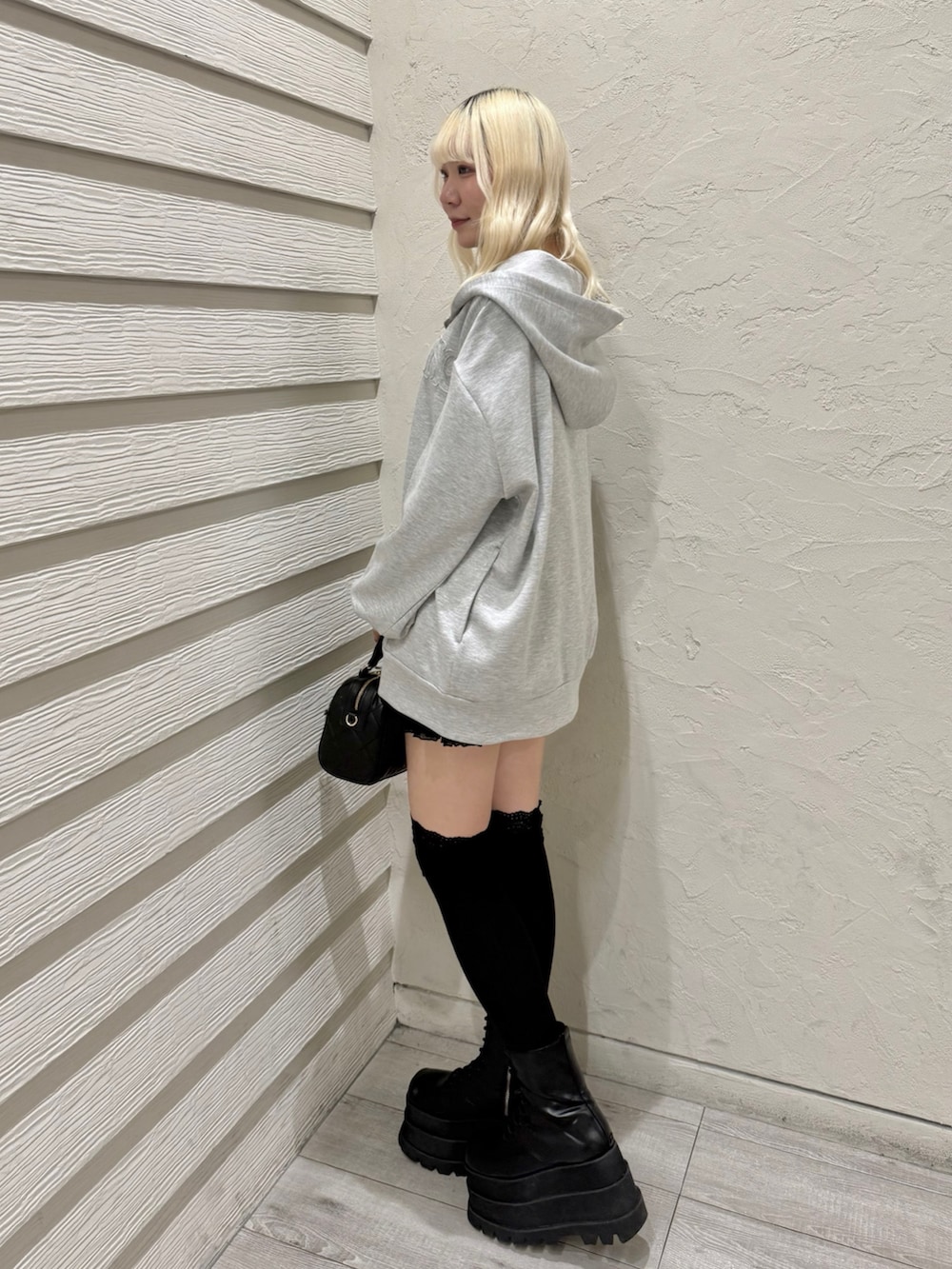 グレー系のパーカー、ブラック系のキャミソール、ブラック系のスカートを着用したレディースの冬コーディネートの2枚目の写真