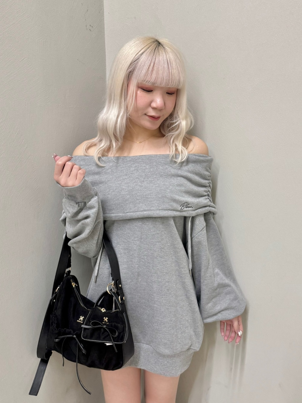 グレー系のパーカー、ブラック系のショルダーバッグ、ブラック系のスニーカーを着用したレディースの春コーディネートの4枚目の写真