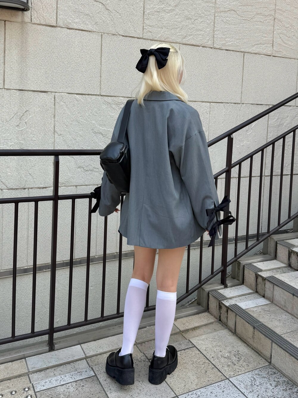 ブラック系のスカート、グレー系のその他アウター、ホワイト系のTシャツ/カットソーを着用したレディースの春コーディネートの3枚目の写真