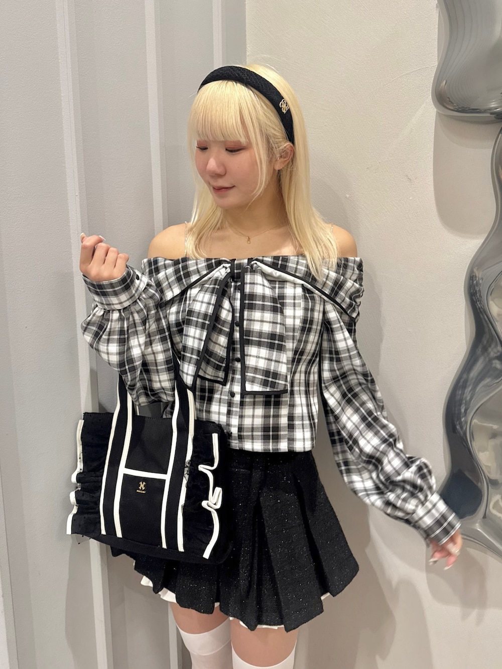 ホワイト系のシャツ/ブラウス、ブラック系のスカート、ブラック系のパンプスを着用したレディースの春コーディネートの4枚目の写真