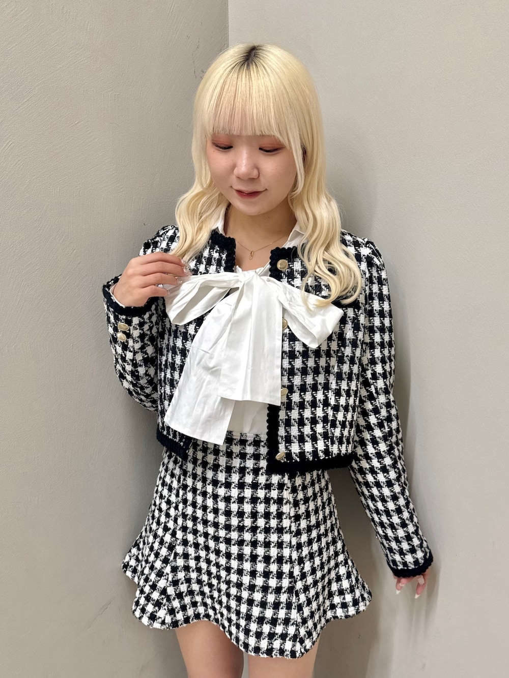 ブラック系のノーカラージャケット、ホワイト系のシャツ/ブラウス、ブラック系のスカートを着用したレディースの秋コーディネートの3枚目の写真